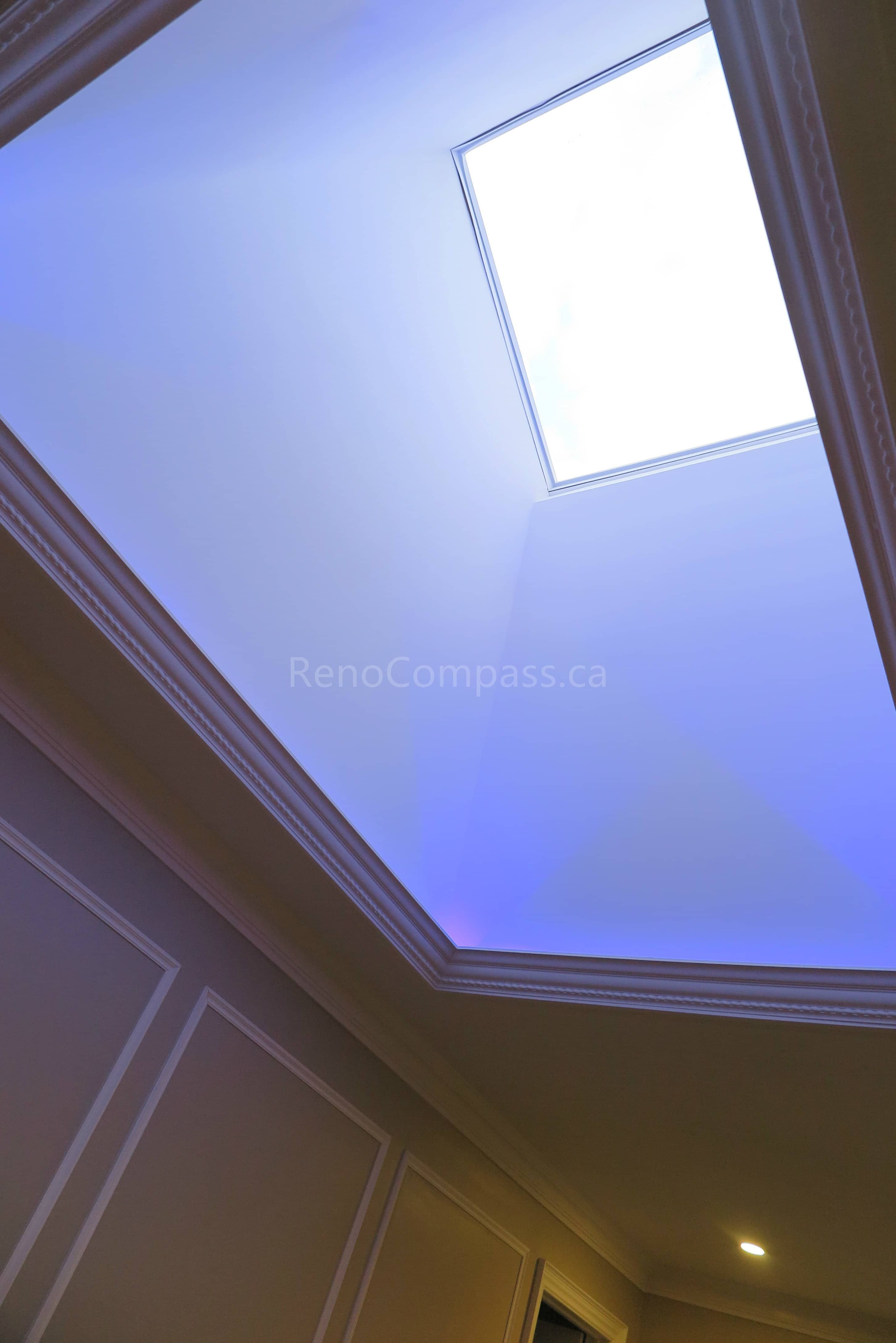 This Markham interior renovation features a custom tray ceiling design with integrated ambient lighting and a central skylight that enhances natural brightness throughout the space. Detailed crown molding and wall panel finishes add architectural elegance, creating a refined and modern interior atmosphere. Completed by Reno Compass, a trusted renovation contractor specializing in custom ceiling design and full home interior renovations across Markham and the Greater Toronto Area.
