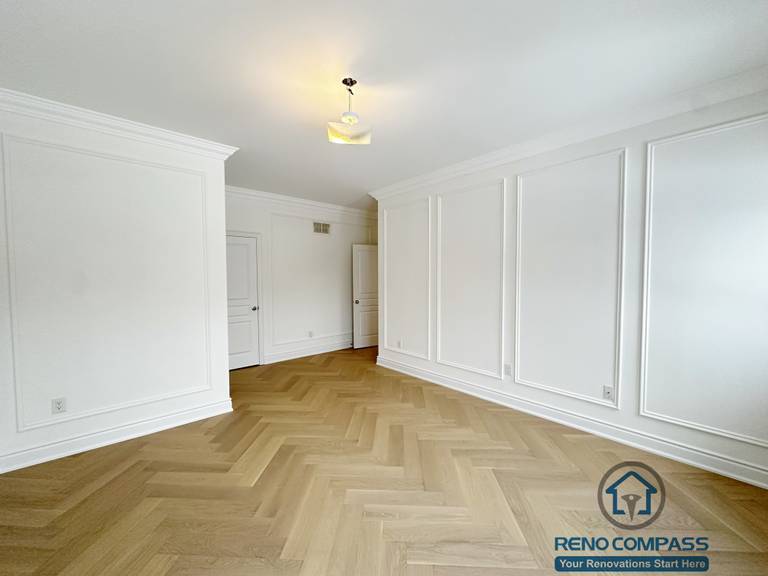 Refined hallway completed as part of a Vaughan interior renovation, featuring custom wall paneling, crown moulding, clean white finishes, and herringbone-pattern hardwood flooring. The balanced proportions and seamless detailing highlight the craftsmanship of a professional Toronto renovation company.