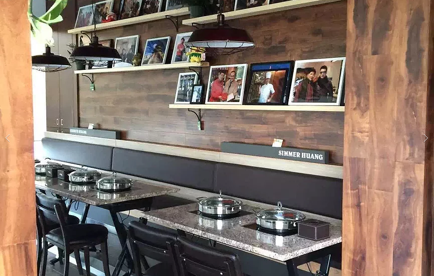 This Markham restaurant renovation by Reno Compass Inc. features a stylish dining wall with custom wood paneling, floating display shelves, and warm pendant lighting. The seating area is designed with durable stone-top tables and comfortable bench seating to enhance both aesthetics and functionality. Decorative photo displays and modern finishes create a welcoming and personalized dining environment, reflecting thoughtful commercial interior design and quality craftsmanship.