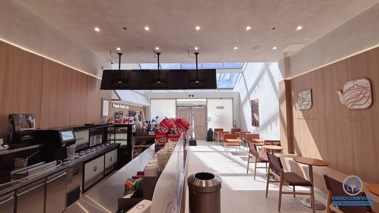 Completed TEABYDO bubble tea shop renovation in Richmond Hill featuring an open-concept beverage preparation counter, modern café seating area, skylight ceiling, custom wood-tone commercial millwork, integrated LED lighting, and clean minimalist interior design. This commercial renovation project was completed by Reno Compass serving Richmond Hill, Toronto, and the GTA.