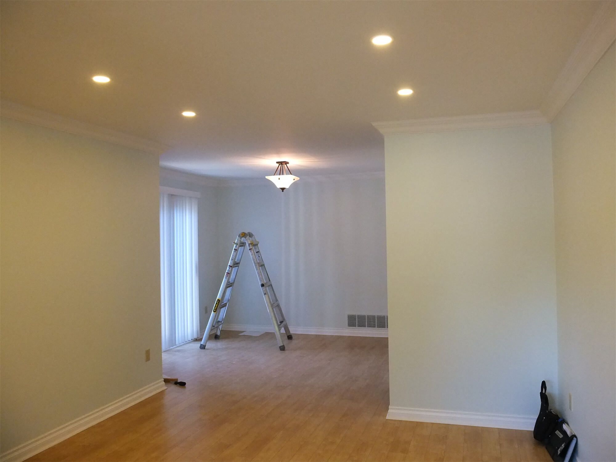 This Oshawa interior renovation project showcases a bright and refreshed open-concept living and dining area. The space features newly refinished hardwood flooring, smooth ceiling with recessed pot lights, upgraded crown molding, and a clean neutral wall palette to enhance natural light. The updated lighting layout improves functionality while creating a warm and inviting atmosphere. Completed with precision and attention to detail, this project reflects the professional craftsmanship of a trusted Toronto Renovation Company, delivering a modern and cohesive interior transformation.