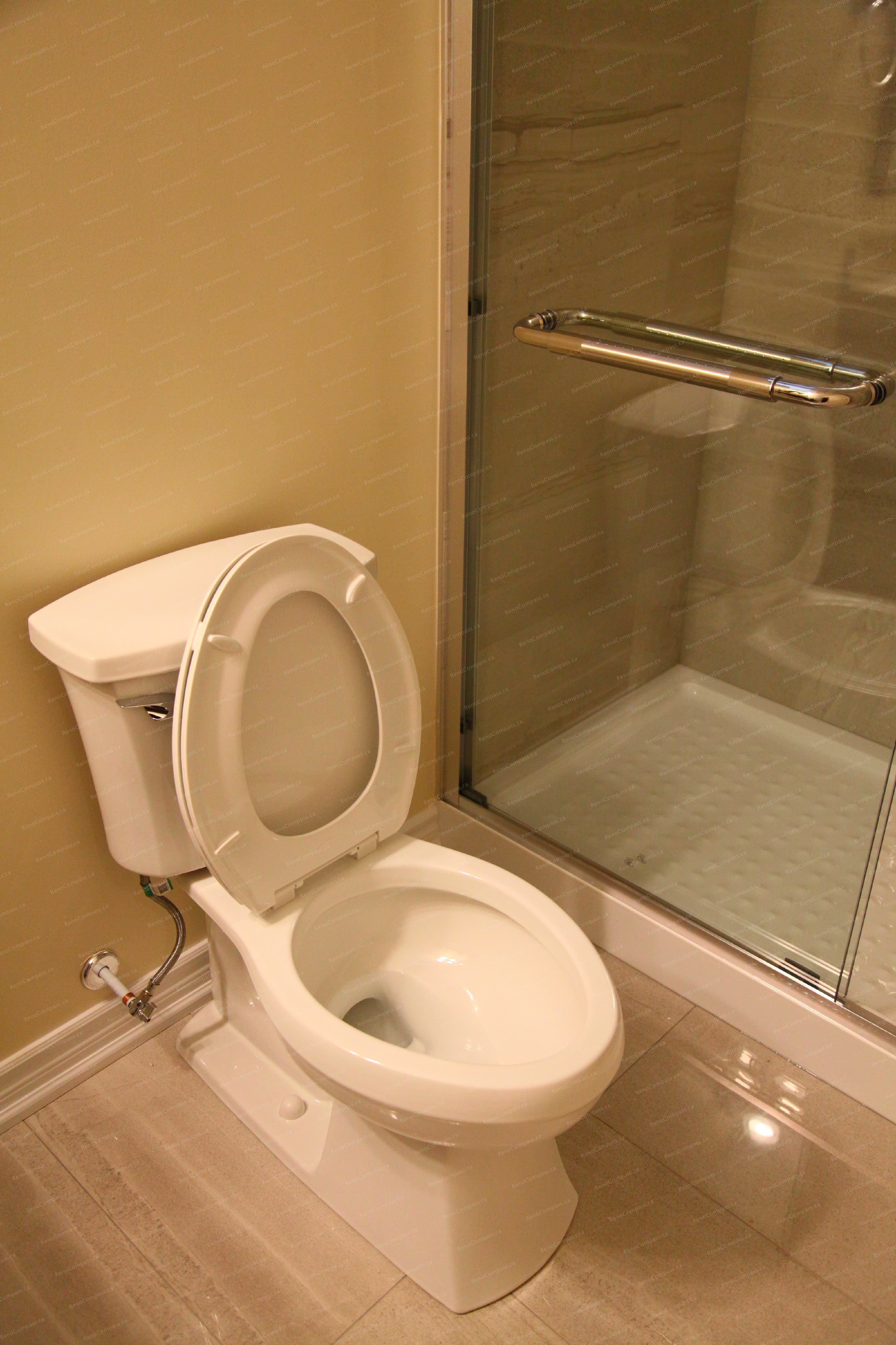 This image shows the toilet area within a finished basement bathroom in a Markham basement renovation project. Positioned beside a glass shower enclosure, the layout maximizes space efficiency while maintaining comfort and accessibility. Clean tile flooring and well-aligned fixtures contribute to a practical and easy-to-maintain basement bathroom, completed by a professional Toronto renovation company.