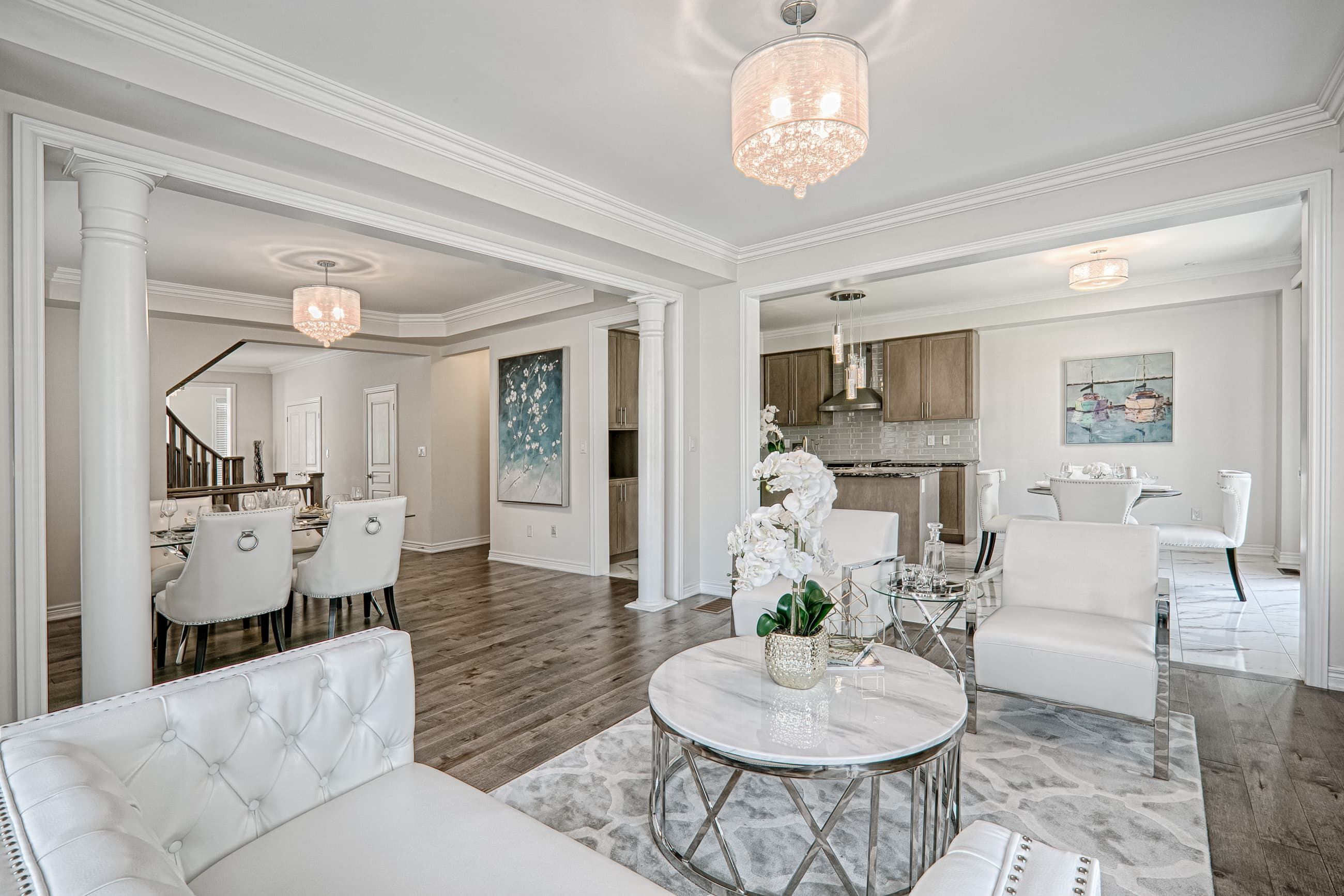 This Toronto luxury open-concept interior renovation showcases a seamless flow between the living room, dining area, and kitchen with elegant modern classic design. Featuring premium hardwood flooring, custom columns, refined ceiling details, and high-end lighting fixtures, the space creates a bright and sophisticated residential environment. Completed by a professional Toronto renovation company, this whole-house interior project highlights functional layout planning, upscale finishes, and timeless design tailored for modern family living.