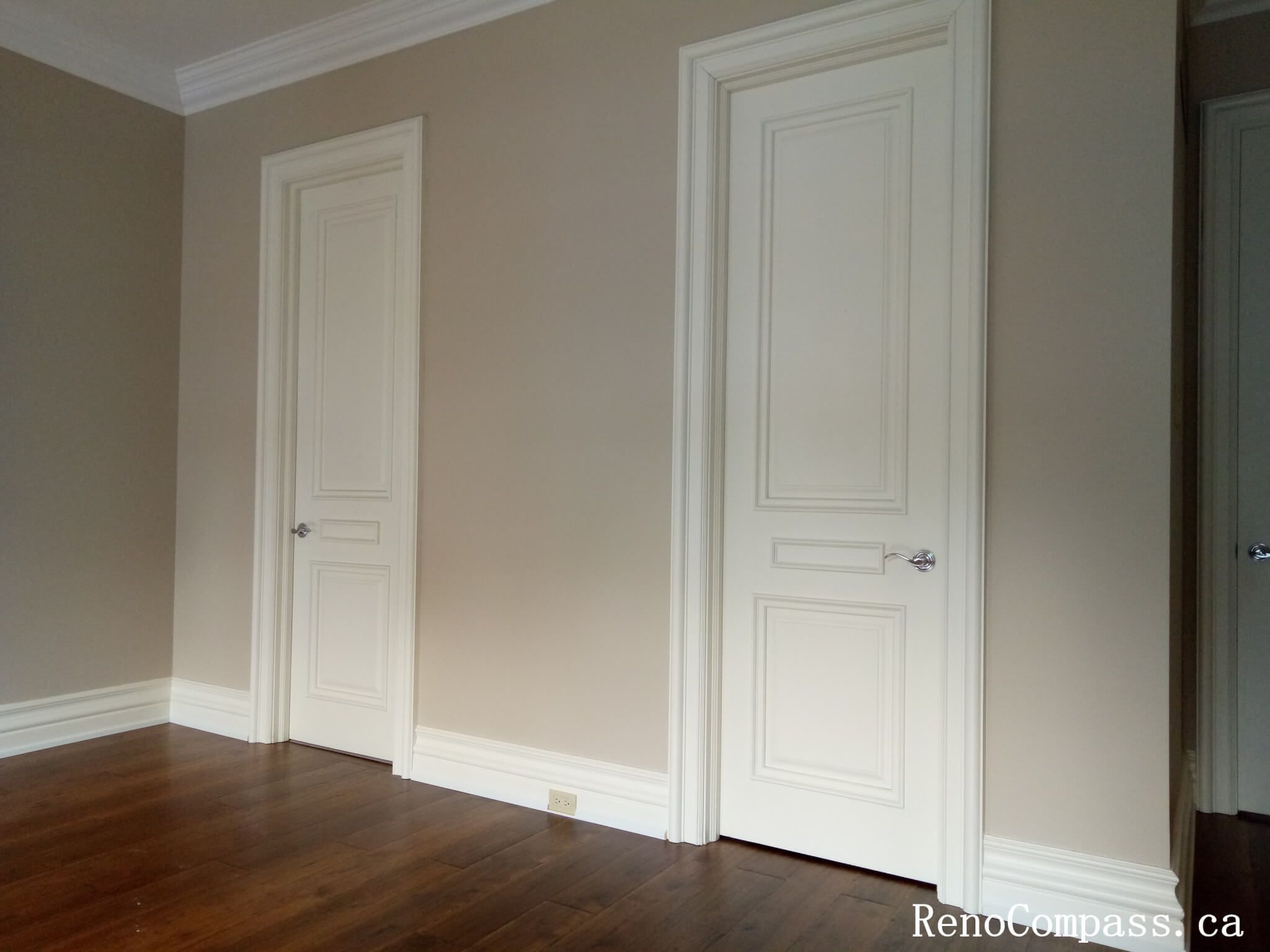 This image presents a completed interior painting project in North York, showcasing a clean hallway space with freshly painted walls, detailed door trim, and crisp crown molding. The soft neutral wall color enhances the depth of the corridor while complementing the white doors and trim for a refined, cohesive look. Smooth transitions between walls, ceilings, and baseboards highlight careful preparation and professional application. This North York painting project reflects high-quality craftsmanship, creating a bright and elegant interior finish suitable for hallways and connecting spaces.