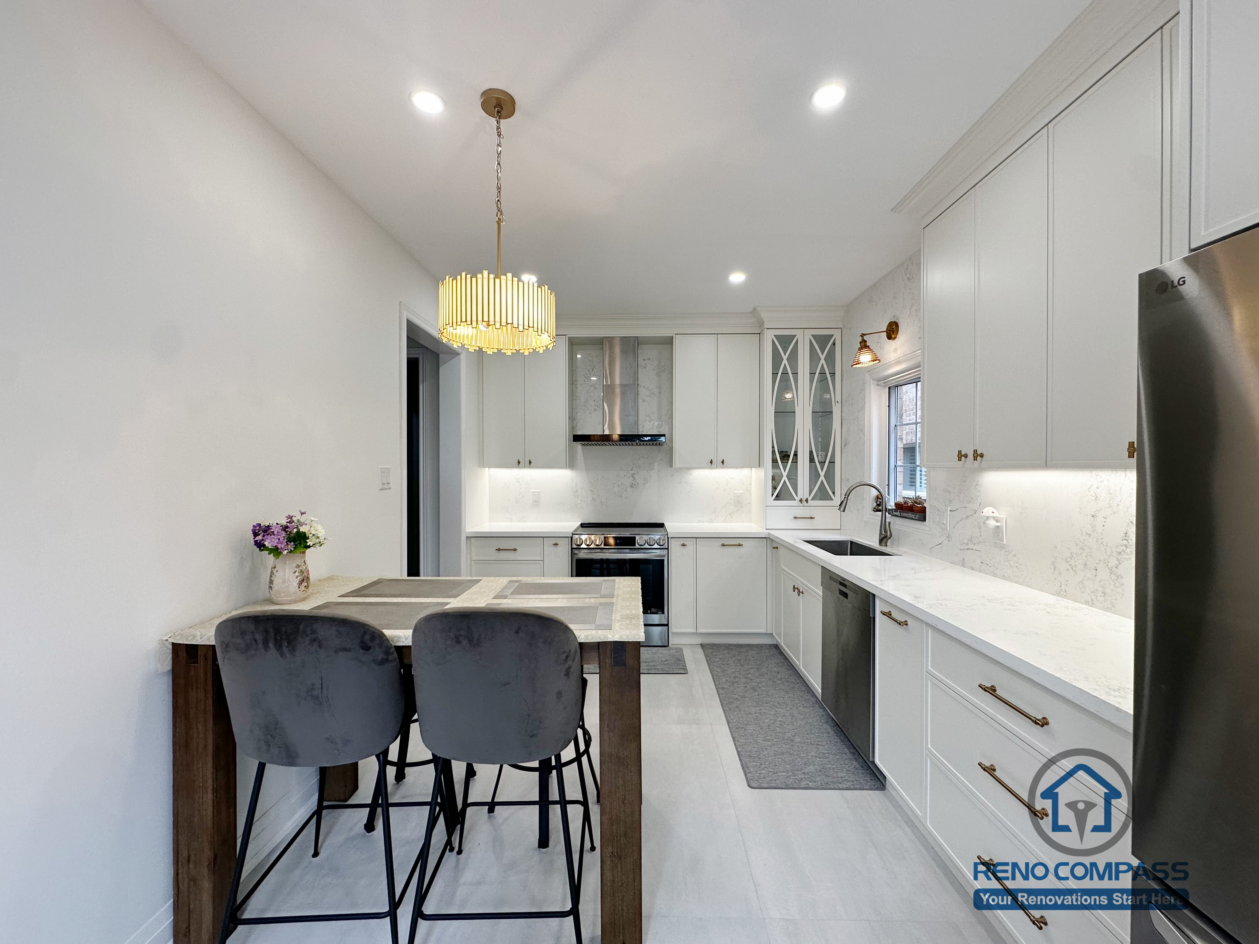 This Markham kitchen renovation showcases a well-balanced U-shaped layout with custom white cabinetry, quartz countertops, and integrated under-cabinet lighting. A compact dining island with seating adds functionality without interrupting workflow, making the space ideal for both daily use and casual gatherings. The gold pendant light introduces a warm focal point, while clean lines and modern appliances keep the overall design bright, efficient, and timeless.