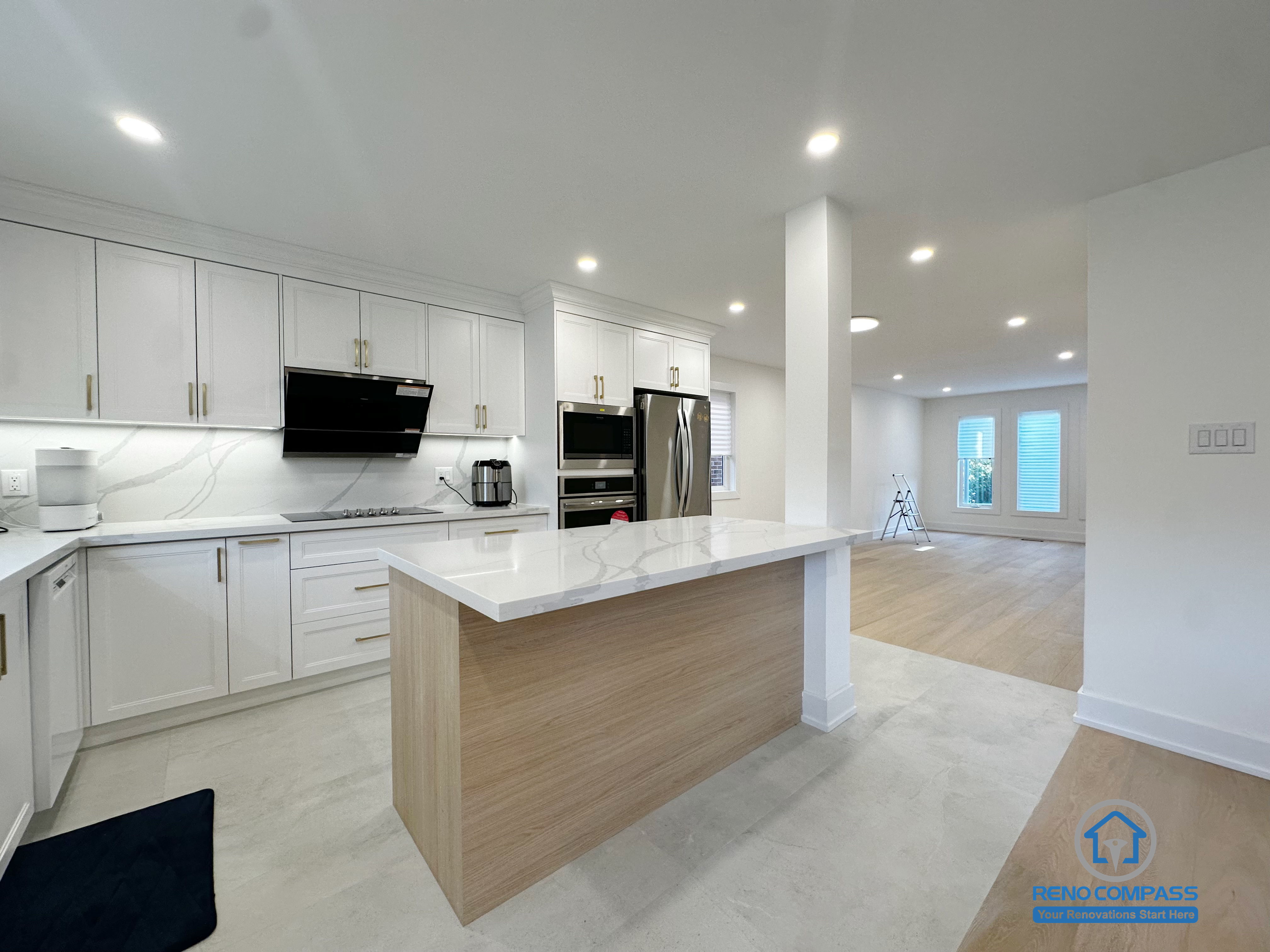 This Richmond Hill interior renovation features an island-centered kitchen layout that smoothly transitions into the adjacent living space. The proportioned island design anchors the kitchen while maintaining openness toward the surrounding areas. White cabinetry, quartz surfaces, and recessed lighting work together to create a balanced and functional environment. Completed as part of a Toronto renovation project focused on spatial continuity, daily usability, and clean modern design.