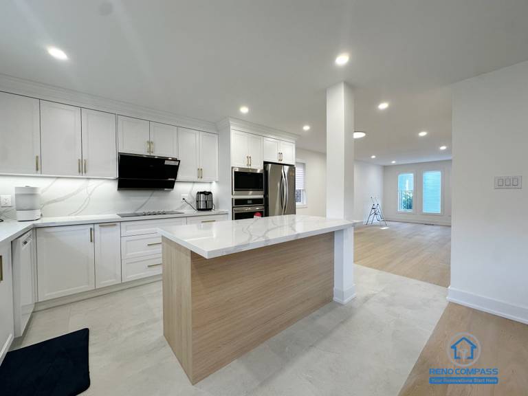 This Richmond Hill interior renovation features an island-centered kitchen layout that smoothly transitions into the adjacent living space. The proportioned island design anchors the kitchen while maintaining openness toward the surrounding areas. White cabinetry, quartz surfaces, and recessed lighting work together to create a balanced and functional environment. Completed as part of a Toronto renovation project focused on spatial continuity, daily usability, and clean modern design.