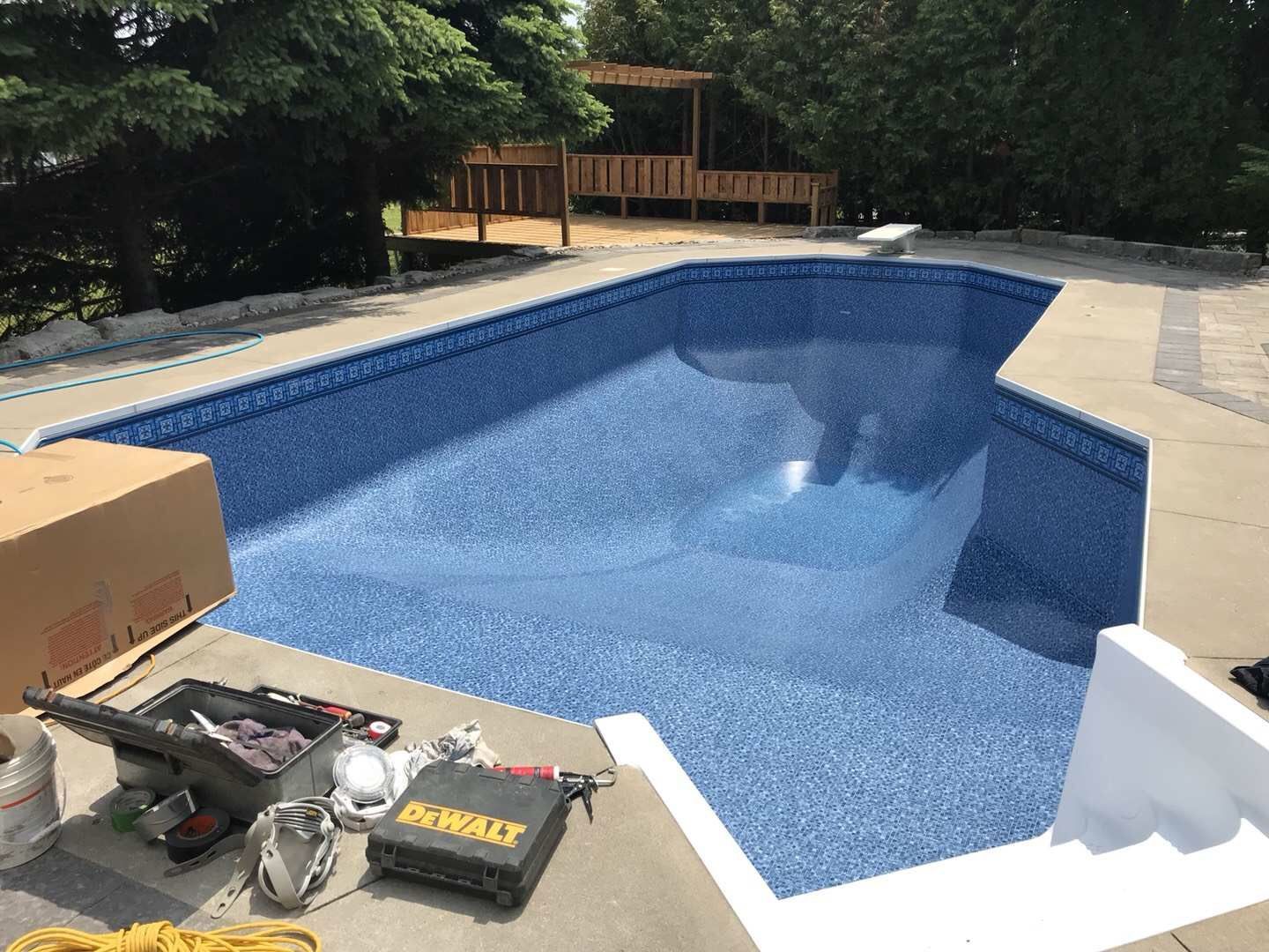 After renovation photo of a fully restored backyard swimming pool in Toronto. The new bright blue liner, clean water, and resurfaced edges highlight the professional pool transformation from old and damaged to modern and inviting. Expert pool renovation by local Toronto specialists.