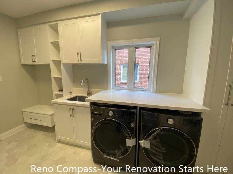 Compact bathroom vanity design in an Oakville interior renovation, showcasing efficient layout, floating wood-finish cabinetry, and contemporary lighting. This renovation focuses on maximizing space while maintaining a clean, modern aesthetic completed by a professional Toronto renovation company.