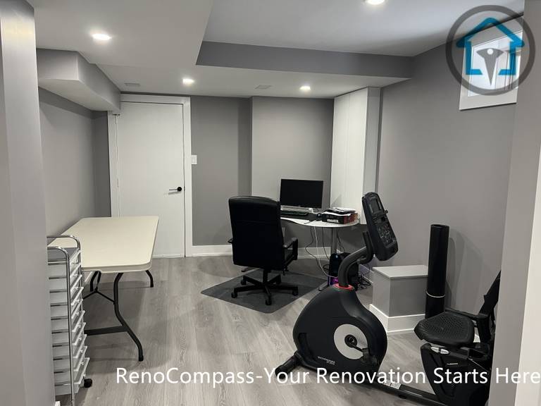 This Vaughan basement renovation features a dedicated home office and multi-functional workspace designed for work-from-home and flexible daily use. The space includes recessed ceiling lighting, durable wood-look flooring, neutral gray wall finishes, and a practical layout that accommodates office furniture and fitness equipment. Completed by a Toronto renovation company, this basement renovation highlights adaptable space planning tailored to modern lifestyle needs.