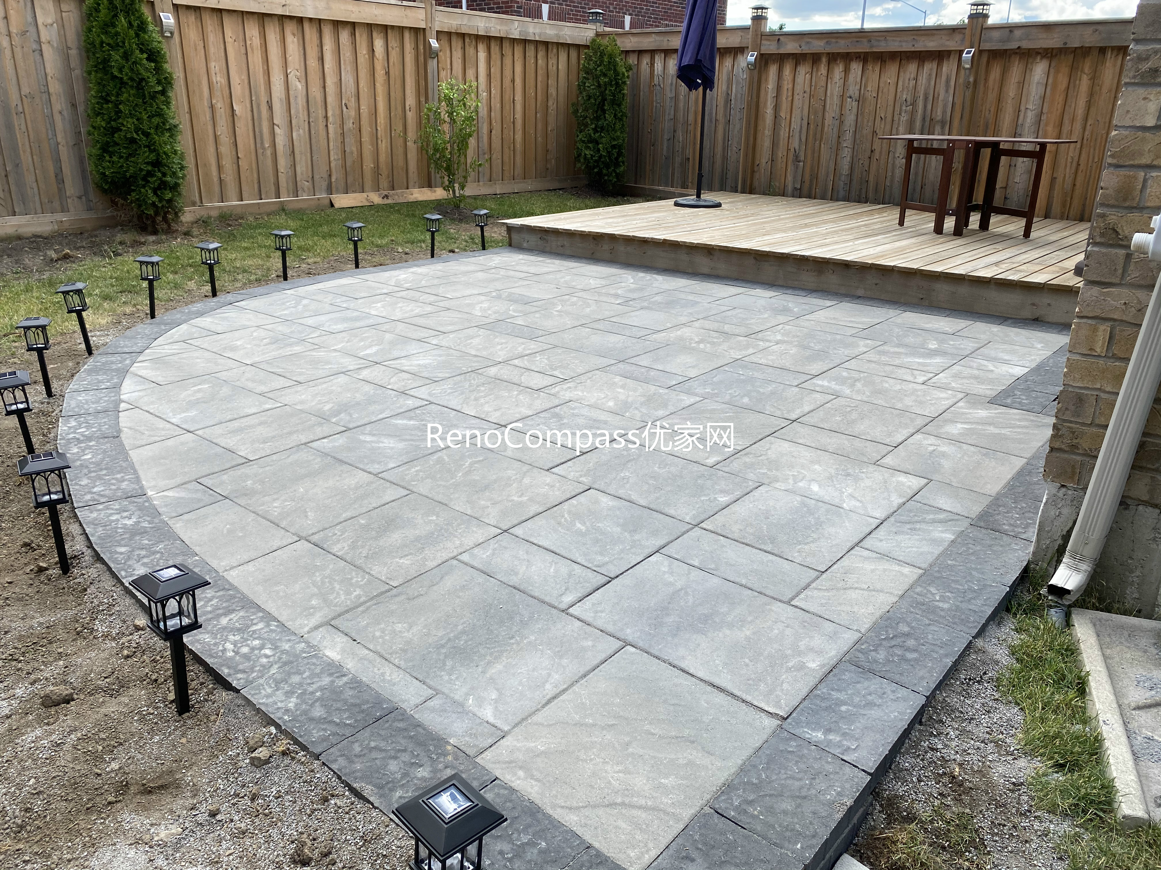 This Markham backyard renovation features a professionally installed interlocking stone patio with a smooth curved edge and contrasting stone border. Large-format gray pavers create a clean, modern surface that seamlessly connects to the raised wooden deck, enhancing both functionality and outdoor aesthetics. Designed for durability and low maintenance, this patio provides an elegant outdoor living space suitable for gatherings, relaxation, and everyday use.