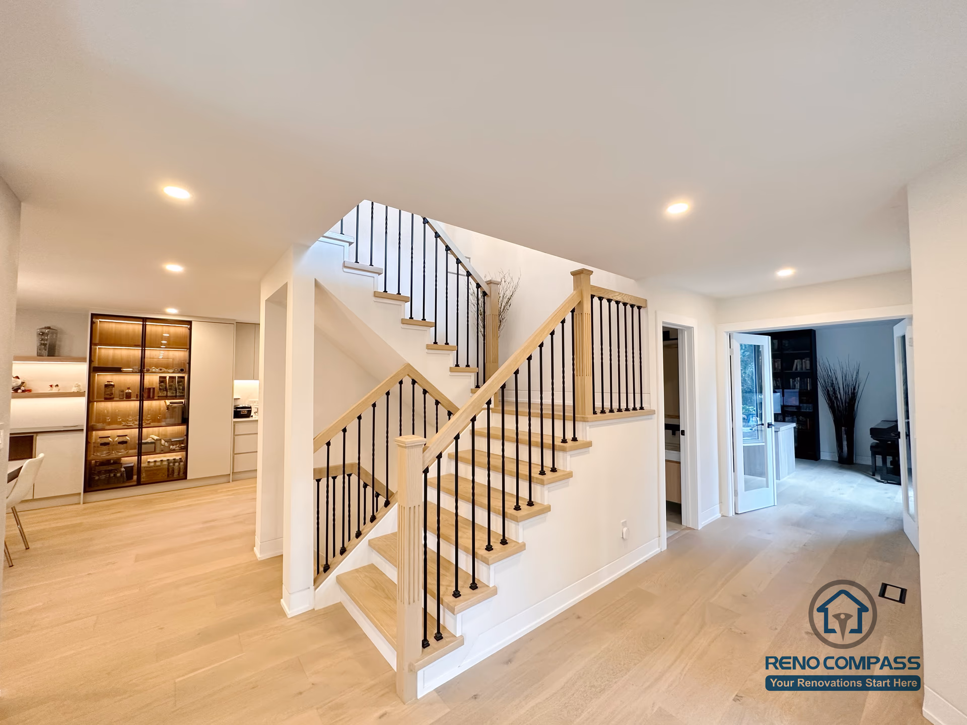 This Toronto stair and flooring renovation features custom hardwood stairs, black metal railings, and light oak hardwood flooring throughout an open-concept interior. The seamless transition between staircases and flooring enhances spatial flow, natural light, and visual balance, showcasing high-quality craftsmanship ideal for modern Toronto home renovations.