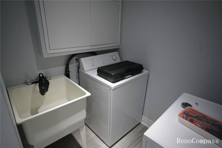Clean and modern basement laundry room featuring a utility sink, upgraded flooring, fresh wall paint, and organized cabinetry. This image highlights quality renovation work in a Mississauga home, showcasing improved functionality and a well‑designed laundry setup.