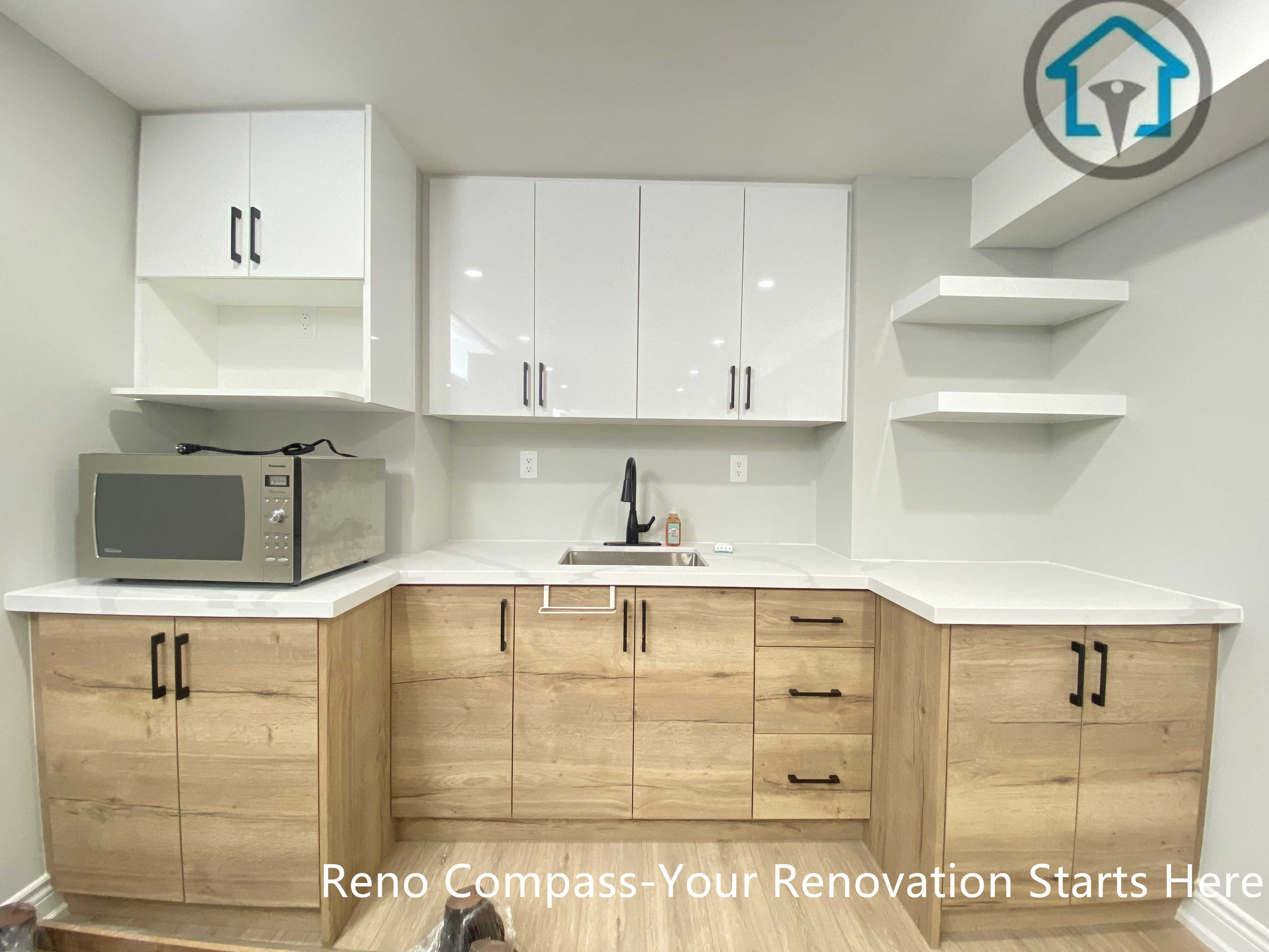A custom basement kitchen area designed as part of a full basement renovation in Stouffville. This space features two-tone cabinetry, quartz countertops, integrated storage, open shelving, and functional workspace planning suitable for daily use or entertaining.