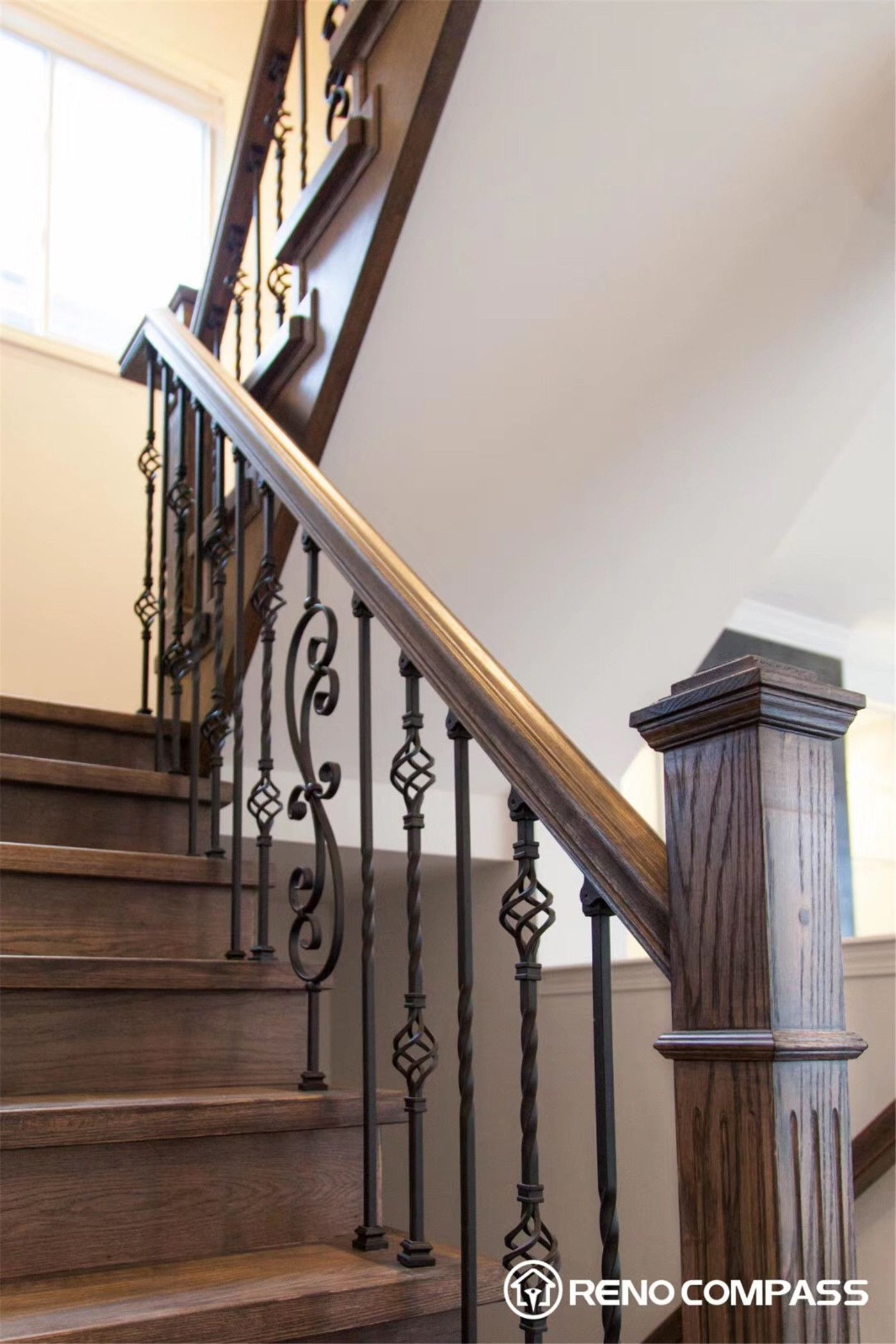 This Markham interior renovation features an open concept layout connecting the living and dining areas with seamless hardwood flooring. The space is enhanced by modern pendant lighting, large windows for natural light, and a stylish staircase with iron railings, creating a clean, spacious, and contemporary home environment.