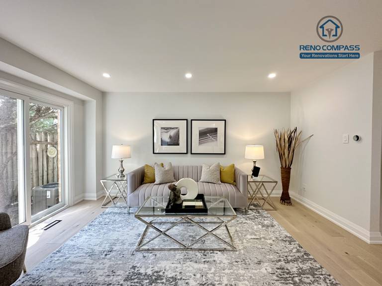 This Richmond Hill interior renovation showcases a modern living room with wide-plank hardwood flooring, recessed ceiling lighting, and a clean neutral color palette. Large sliding glass doors bring in natural light, while the staged furnishings highlight comfort and functionality. Completed by a Toronto renovation company, the space reflects contemporary design and refined craftsmanship.