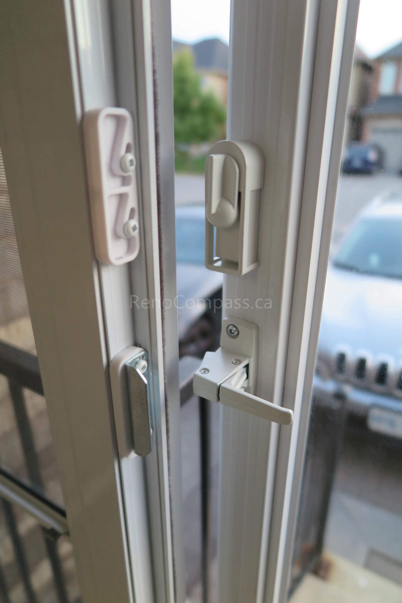 Close-up detail of the door handle and lock system from a Markham storm door installation completed by Reno Compass Inc. The elegant white finish and premium hardware ensure smooth operation, strong security, and a clean modern look for the home exterior.