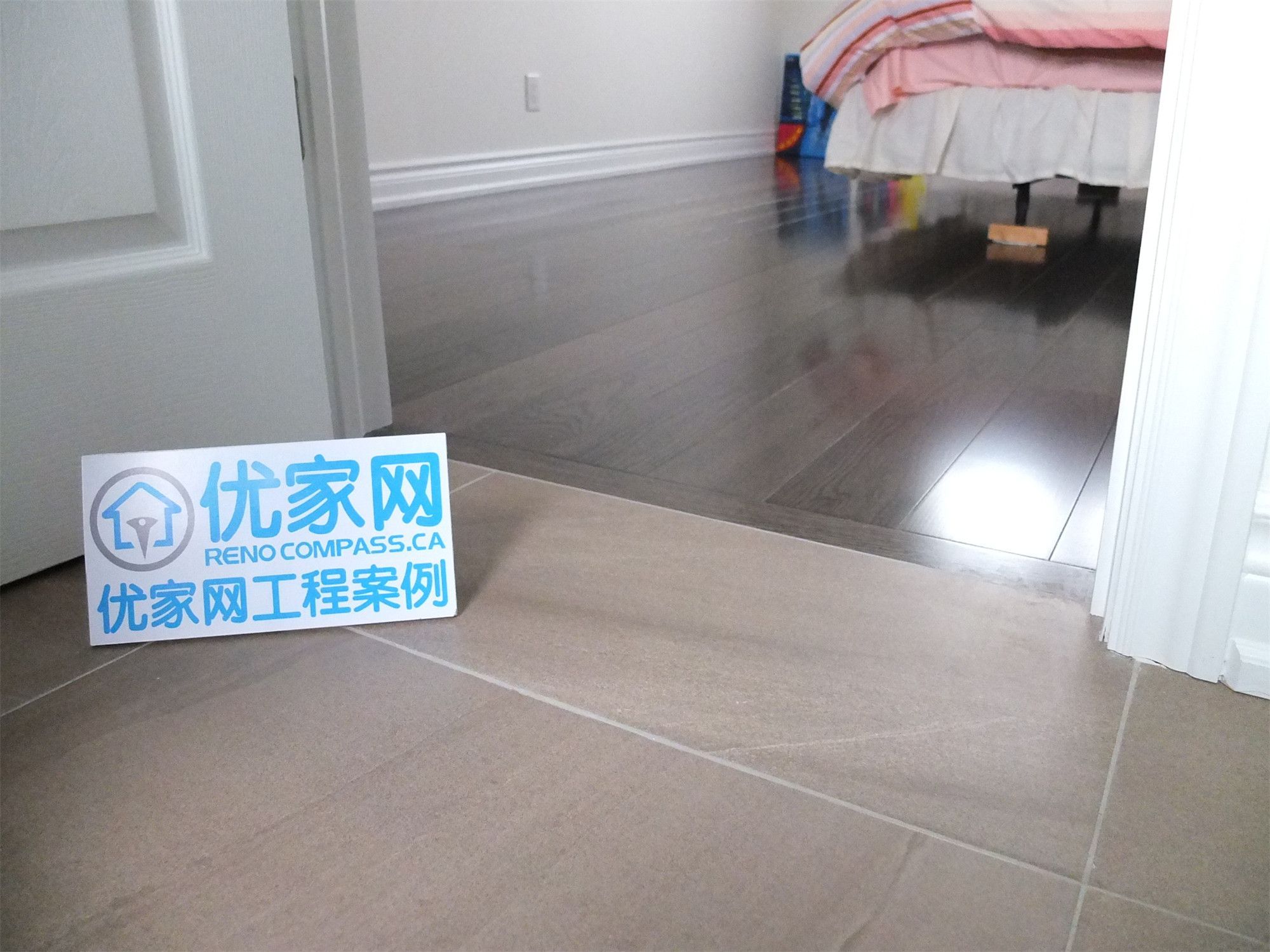 Bedroom entrance area from a Scarborough home addition project showing the transition between ceramic floor tiles and dark hardwood flooring. The renovation highlights clean trim work, smooth floor integration, and modern interior finishes designed for durability and visual continuity.