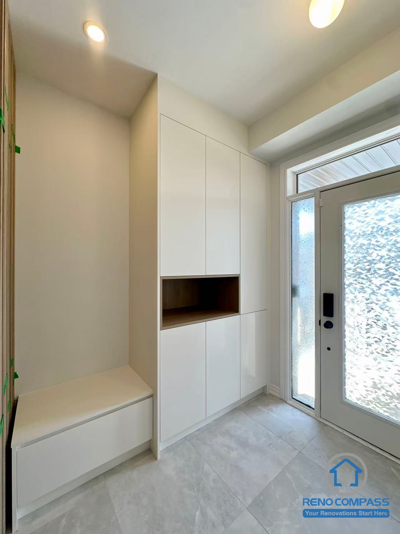 This Stouffville interior renovation features a custom entryway with built-in cabinetry, integrated bench seating, and concealed storage designed for daily functionality. Clean white finishes, recessed lighting, and a streamlined layout create a bright and organized entrance space. Completed by a professional Toronto renovation company, Reno Compass Inc., this project highlights thoughtful entryway planning and high-quality interior craftsmanship.