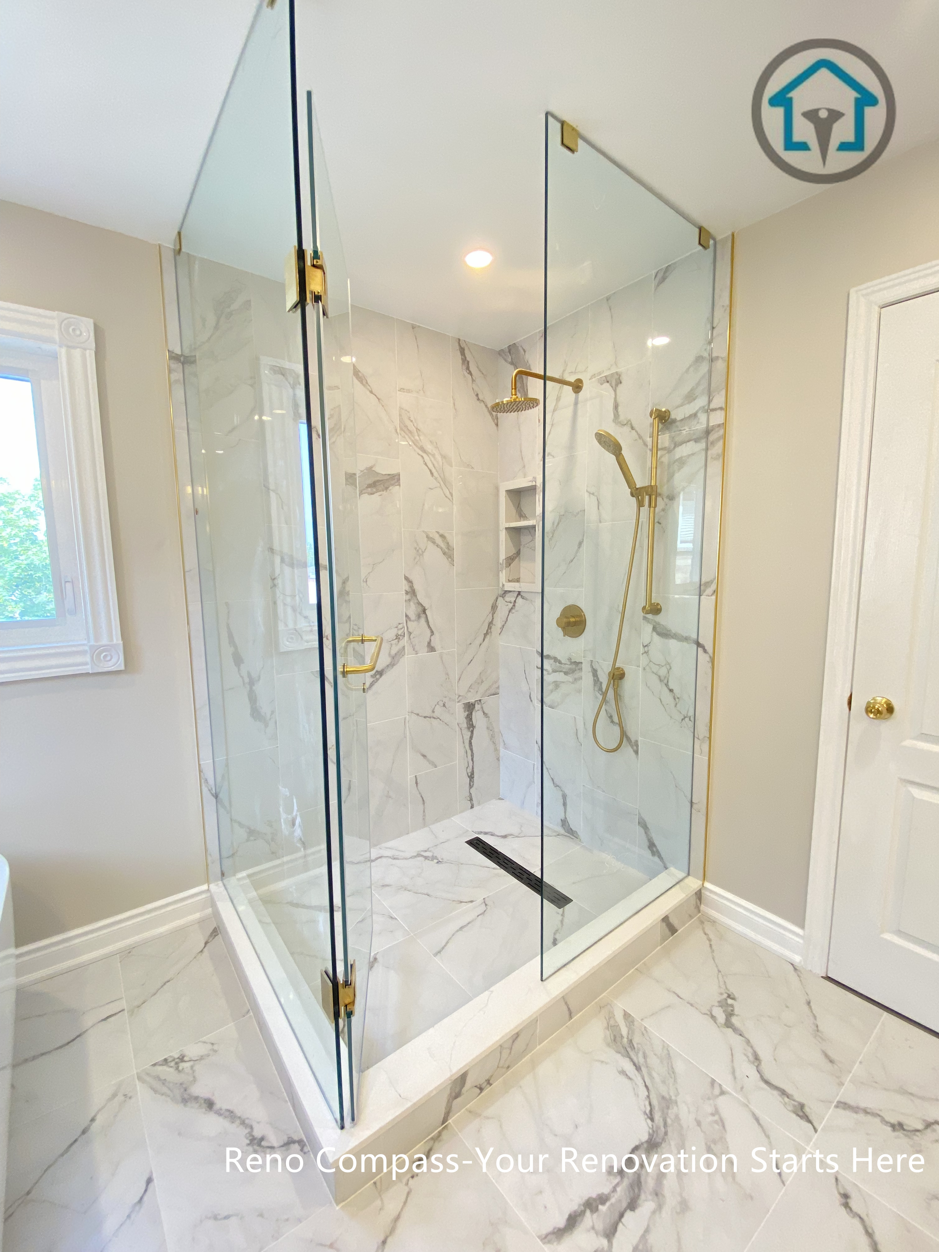 该卫生间采用全玻璃围合的步入式淋浴房设计，最大化引入自然采光，使空间更加通透开阔。淋浴区内部铺贴大规格仿大理石纹瓷砖，墙地统一，线条干净利落。搭配金色五金件与无框玻璃门，提升整体质感与细节完成度。线性地漏与定制壁龛设计兼顾排水效率与日常收纳，整体风格现代而耐看，适合追求品质与实用并重的家庭。