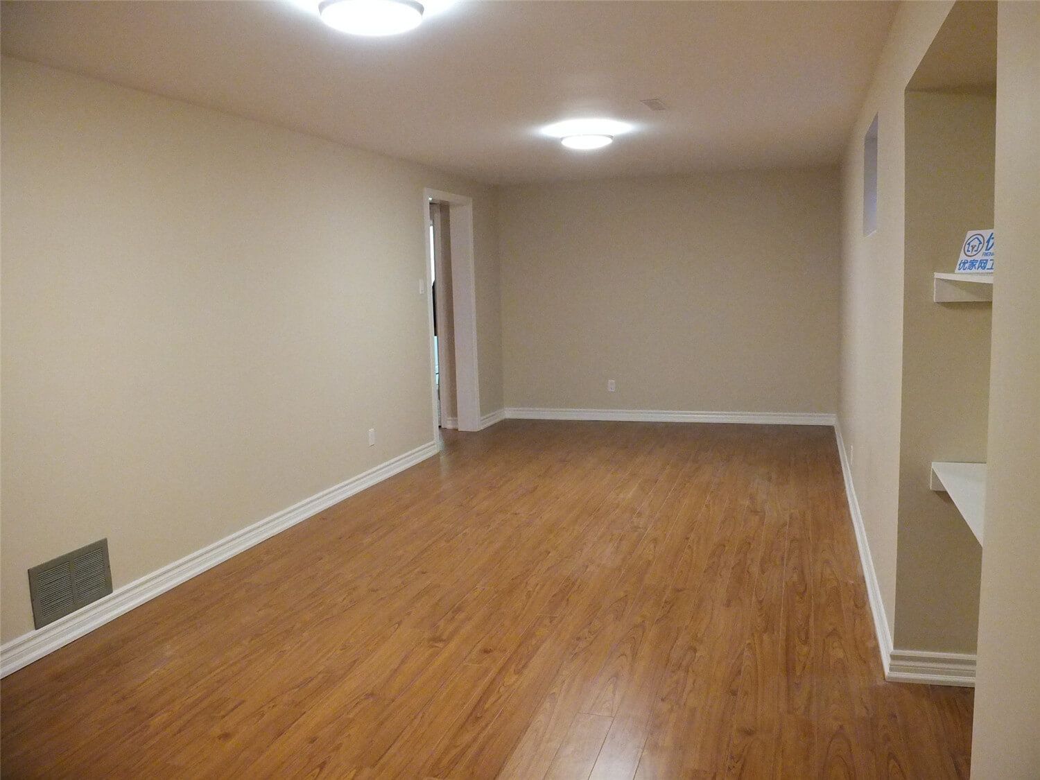 This Markham basement renovation project features newly finished walls, fresh interior painting, and durable laminate flooring installation. The clean wall finish, neutral paint tones, and wood-style flooring create a bright, comfortable living space suitable for a family recreation room or additional living area. Careful detailing around the baseboards and wall edges ensures a smooth and polished appearance throughout the basement interior.
