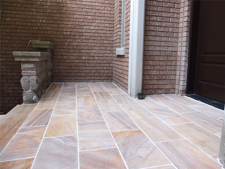 This Richmond Hill front entrance renovation showcases a newly installed interlocking stone porch with durable natural-tone tiles and clean modern finishing. The upgraded entrance landing improves safety, drainage, and curb appeal while complementing the home’s brick exterior and stone pillars. Completed by a trusted Toronto renovation company, this landscaping and interlocking project delivers a refined, long-lasting front entry designed for both functionality and visual impact