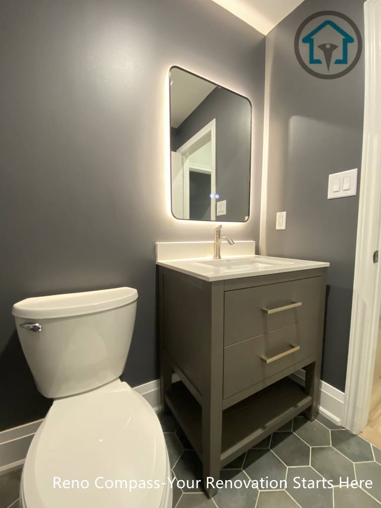 This Richmond Hill bathroom renovation features a modern powder room design with a compact vanity, backlit mirror, and dark wall finishes. The layout maximizes functionality in a small space while maintaining a clean, contemporary look, completed by a trusted Toronto renovation company.