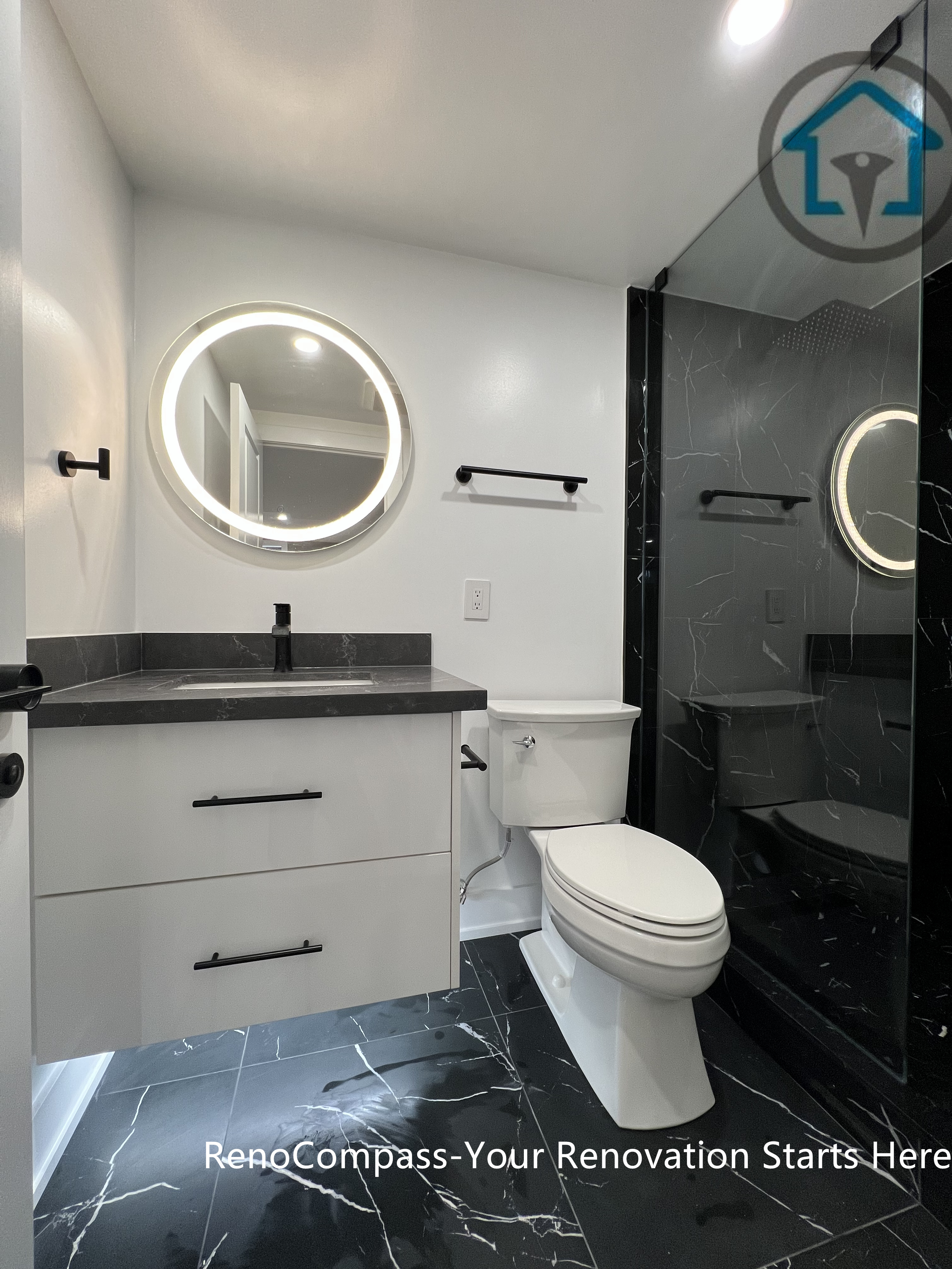 This Vaughan basement renovation features a contemporary full bathroom with a glass-enclosed shower, dark marble-look tiles, a floating vanity, and an LED-backlit mirror. The compact yet efficient layout maximizes comfort and durability while maintaining a clean, modern aesthetic suitable for basement environments. Completed by a Toronto renovation company, this basement bathroom renovation reflects careful material selection and functional space planning.