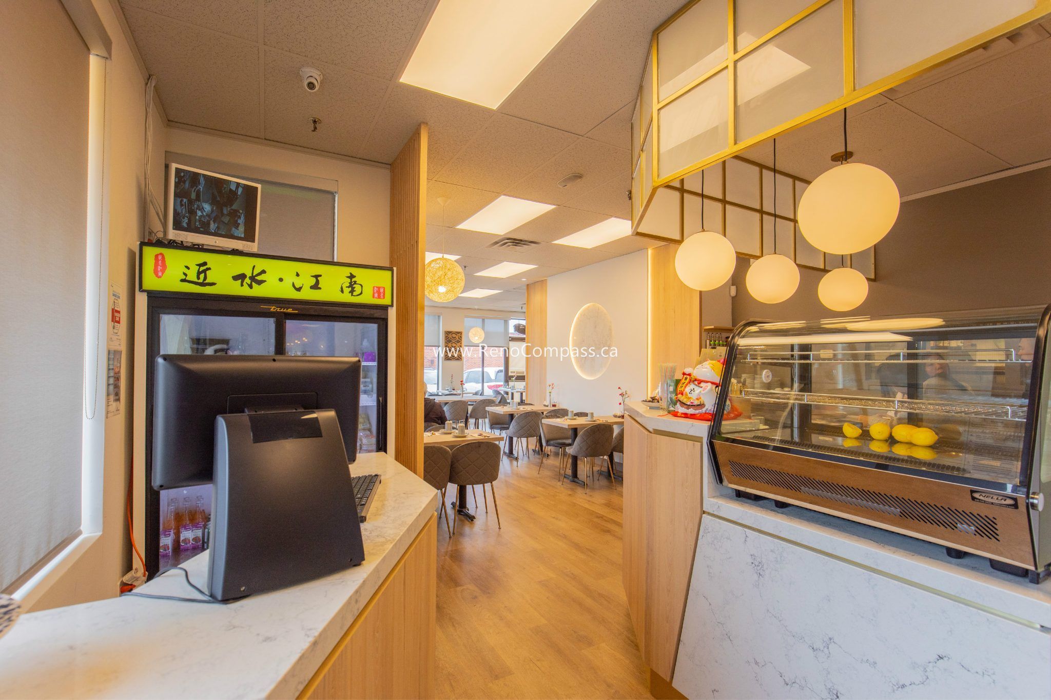 This Chinese restaurant renovation project in Richmond Hill showcases a clean and functional beverage and service counter designed by Toronto renovation company Reno Compass Inc. The upgraded space features custom wood paneling, modern lighting fixtures, organized preparation areas, and a customer-friendly service layout. By optimizing workflow and improving visual appeal, the renovation enhances both staff efficiency and customer experience, creating a warm and modern dining environment suitable for high-traffic restaurant operations.