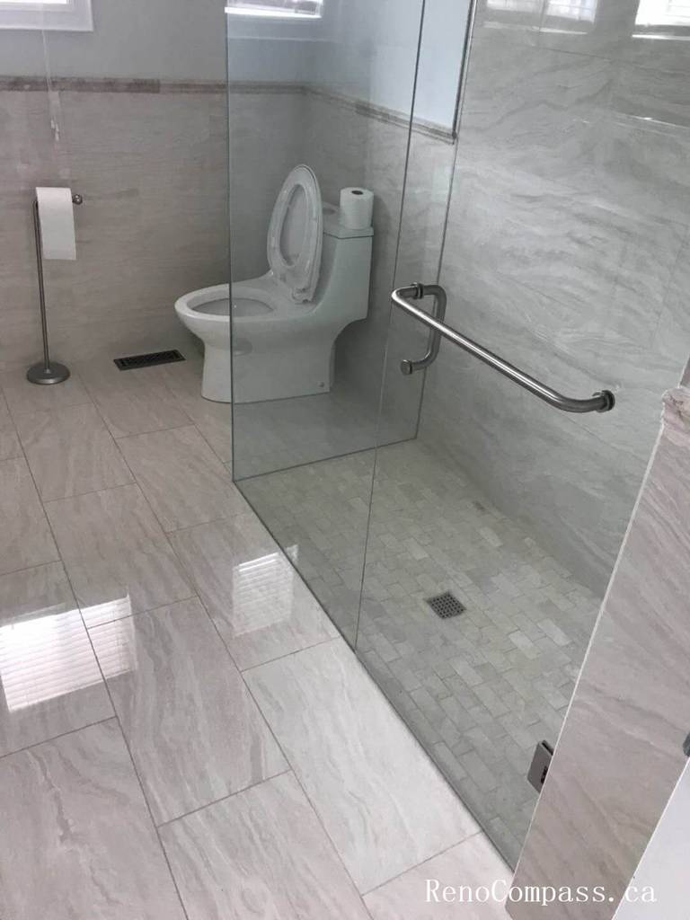 This Markham interior renovation showcases a contemporary bathroom upgrade featuring a frameless glass walk-in shower enclosure and large-format marble-look porcelain tiles. The sleek glass partition enhances openness while providing a clean and modern aesthetic. Neutral-toned wall and floor tiles create a cohesive design, complemented by precision-installed plumbing fixtures and a minimalist layout. The upgraded shower area improves both functionality and long-term durability. Completed with meticulous attention to detail, this bathroom renovation reflects Reno Compass’ commitment to delivering high-quality interior renovation services in Markham and the Greater Toronto Area.