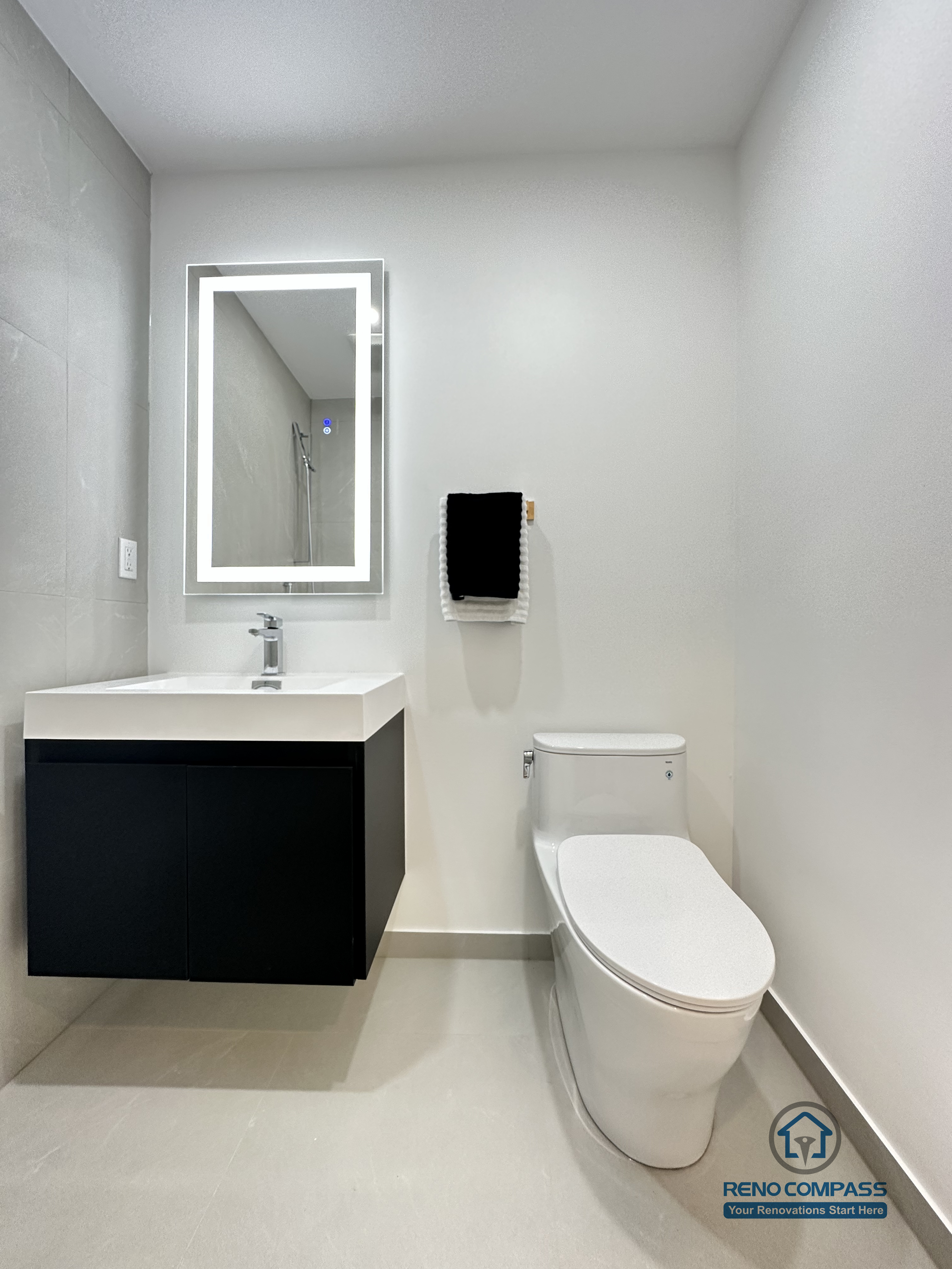 This image showcases a modern accessible pet shower bathroom renovation in Brampton, designed with a clean, barrier-free layout for ease of use. The space features large-format non-slip floor tiles, a wall-mounted floating vanity, an LED backlit mirror, and a compact toilet configuration to maximize maneuverability. The open shower area allows safe and comfortable bathing for pets while remaining fully accessible for homeowners. This type of thoughtful, functional design is ideal for aging-in-place and pet-friendly homes, completed by a professional Toronto Renovation Company with experience in accessibility-focused bathroom solutions.
