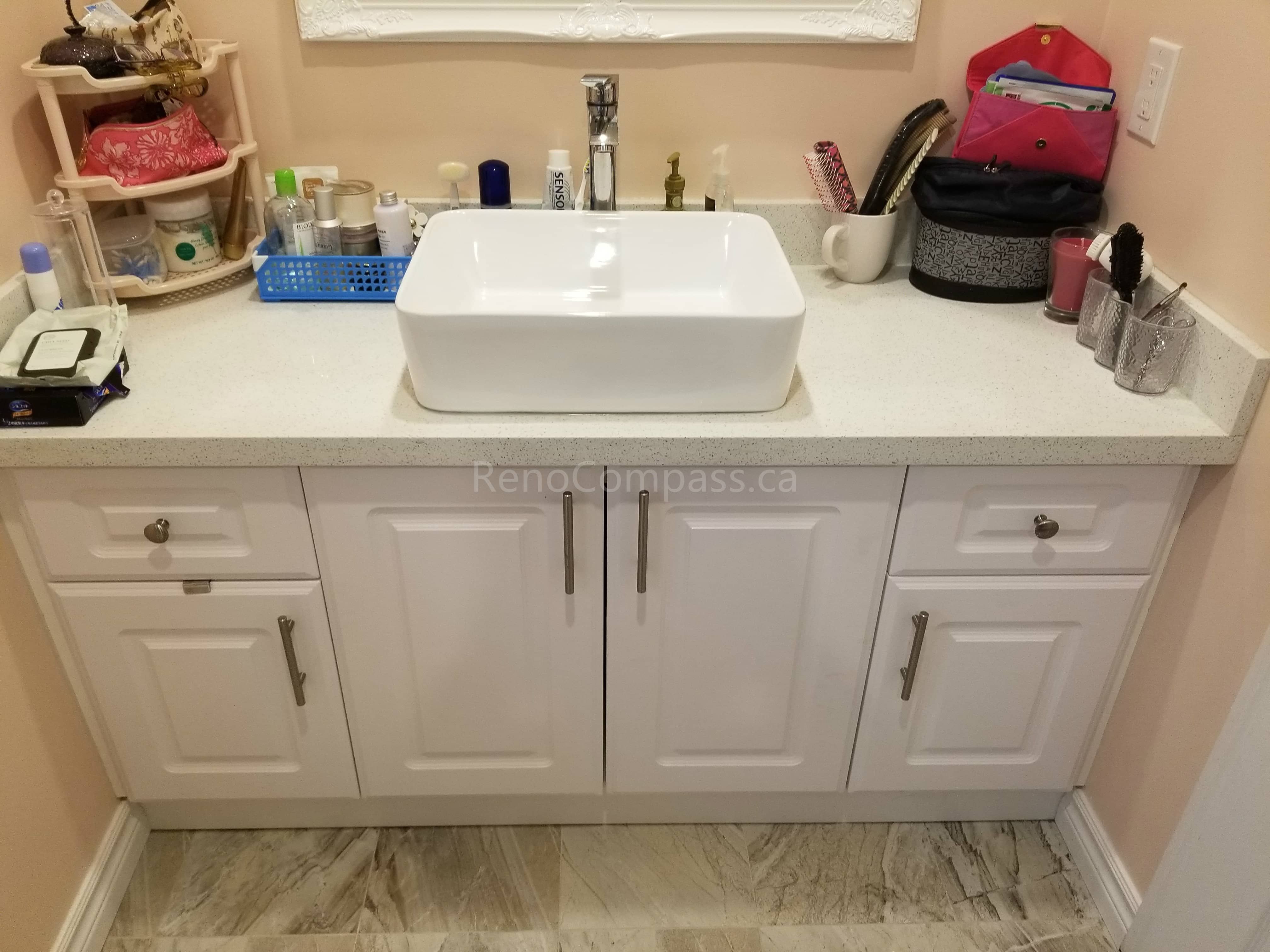 This Markham bathroom renovation includes a newly installed custom vanity with a modern countertop vessel sink and upgraded faucet. The clean white cabinetry provides ample storage while complementing the new floor tiles and overall bathroom design. The refreshed vanity area enhances both functionality and style, creating a bright, organized, and contemporary bathroom space for daily use.