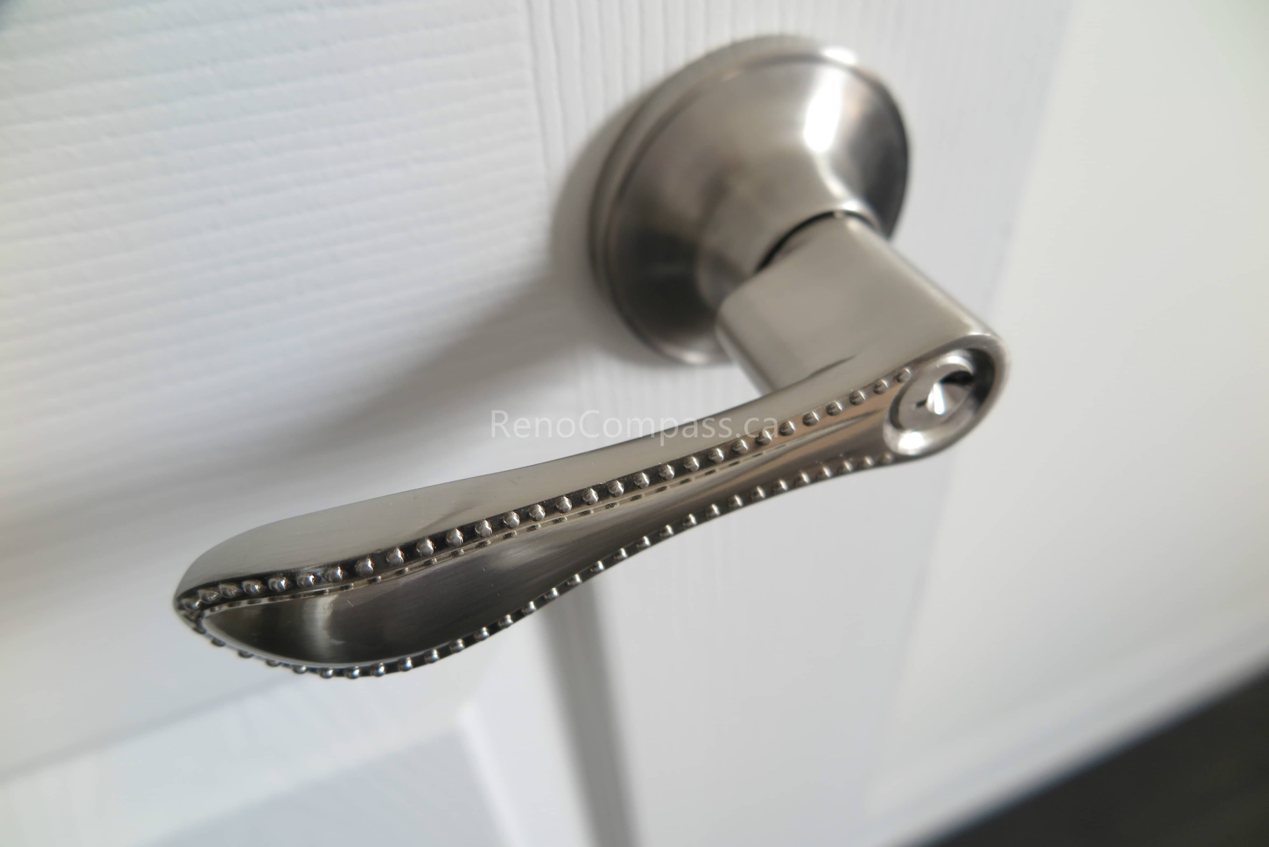 This North York interior renovation features a modern brushed nickel door handle installation that adds both style and functionality to the home. The sleek hardware design complements the clean white door and contemporary interior finishes, enhancing durability and everyday usability. Installed by Reno Compass Inc., this detailed finishing upgrade reflects quality craftsmanship and a refined modern renovation style.