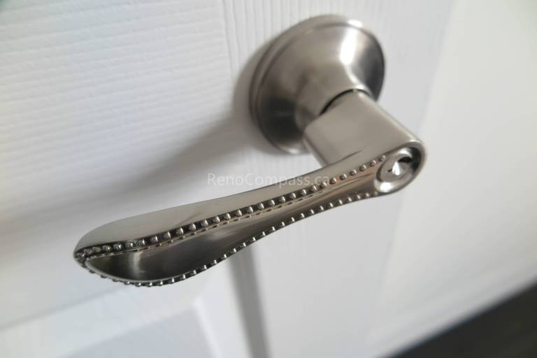 This North York interior renovation features a modern brushed nickel door handle installation that adds both style and functionality to the home. The sleek hardware design complements the clean white door and contemporary interior finishes, enhancing durability and everyday usability. Installed by Reno Compass Inc., this detailed finishing upgrade reflects quality craftsmanship and a refined modern renovation style.
