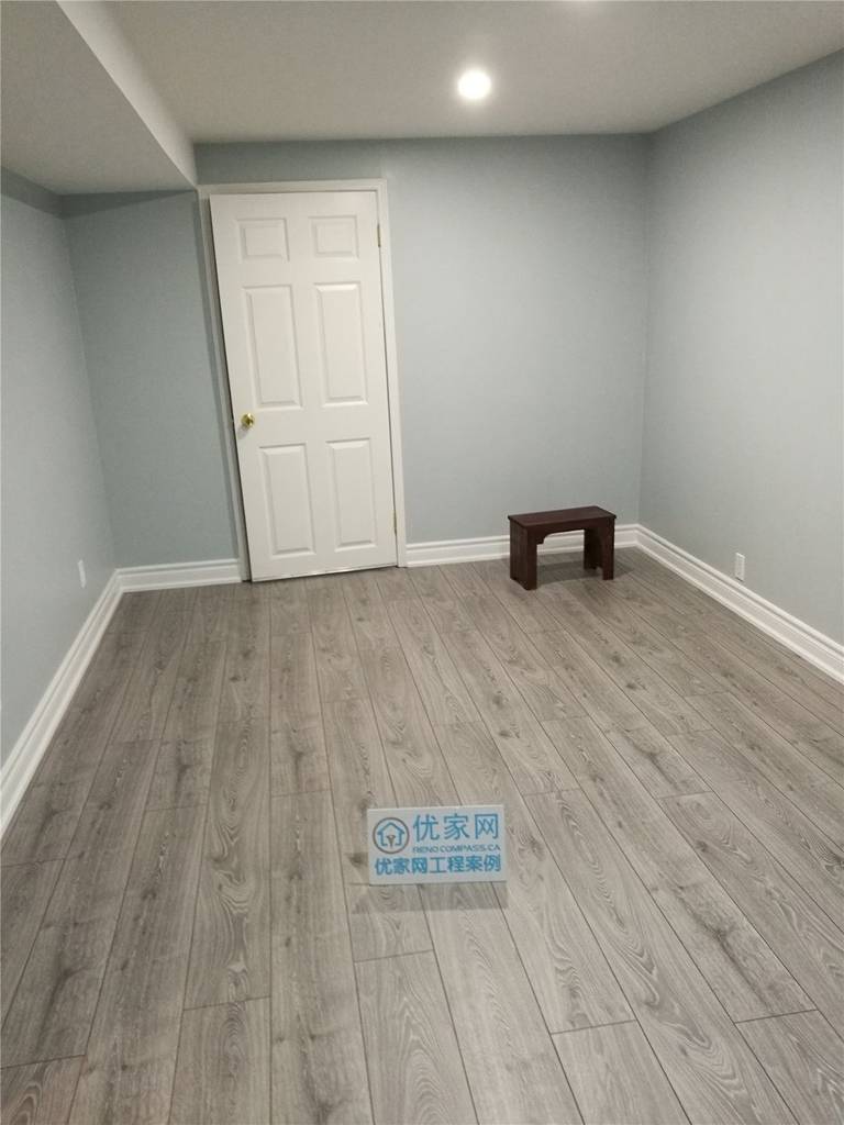 This image showcases a completed interior renovation project in North York, featuring a clean and modern basement room. The space is finished with light grey laminate flooring, soft neutral wall colors, white baseboards, and recessed ceiling lighting, creating a bright and functional environment. The renovation focuses on clean lines, practical layout, and durable materials suitable for long-term residential use. This North York interior renovation highlights quality craftsmanship and attention to detail by a professional Toronto renovation company.