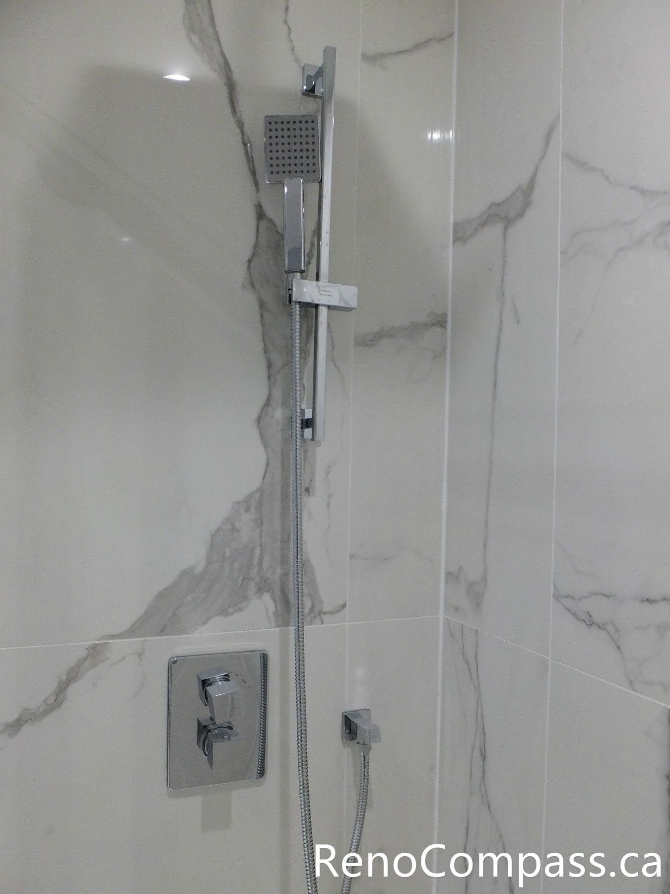 This Richmond Hill bathroom renovation features a modern shower system with a sleek handheld shower set, upgraded control valve, and marble-look porcelain wall tiles. Completed by a professional Toronto renovation company, the installation combines contemporary design, efficient water control, and durable waterproof finishes to create a comfortable and elegant shower experience.