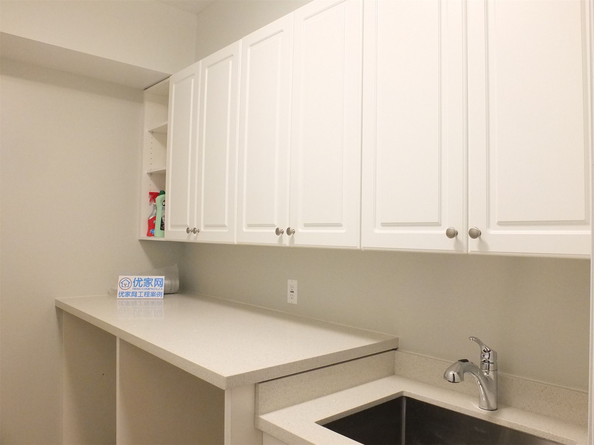 This Richmond Hill basement renovation features a functional utility area with custom cabinetry, a built-in sink, and extended countertop workspace. The clean design maximizes storage and practicality, making it ideal for laundry use, secondary kitchen prep, or additional household functionality.