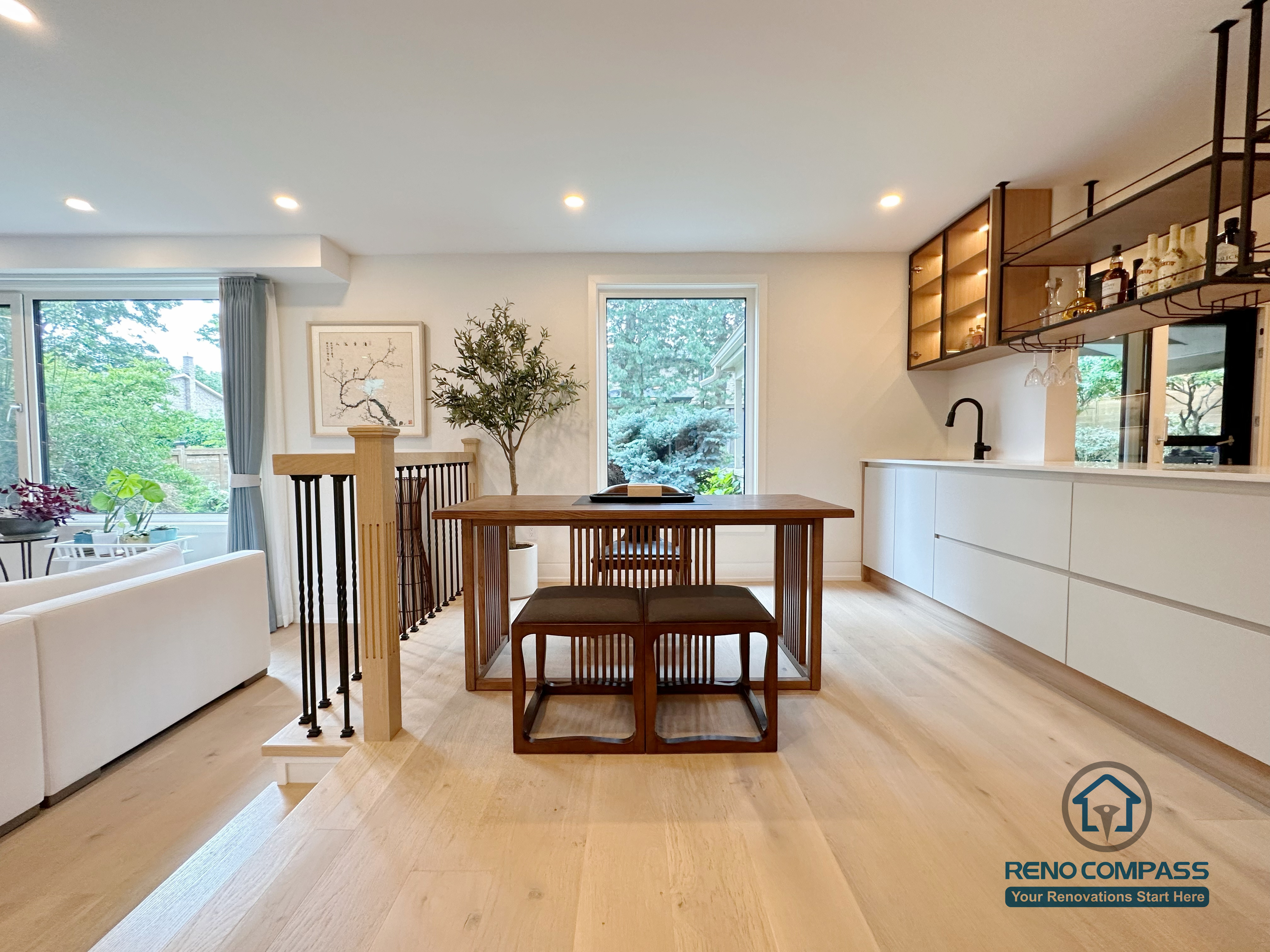 An open-concept kitchen and dining area renovation in Toronto featuring custom cabinetry, a built-in bar and beverage station, and clean-lined storage design. Warm wood flooring, integrated lighting, and seamless circulation create a functional yet elegant living space, completed by a professional Toronto renovation company.