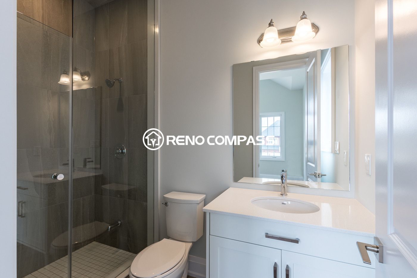 Bright and modern bathroom renovation in Newmarket featuring a glass shower enclosure, contemporary vanity cabinet and quartz countertop. Completed by a trusted Toronto renovation company, this project enhances both style and functionality in a compact bathroom space.