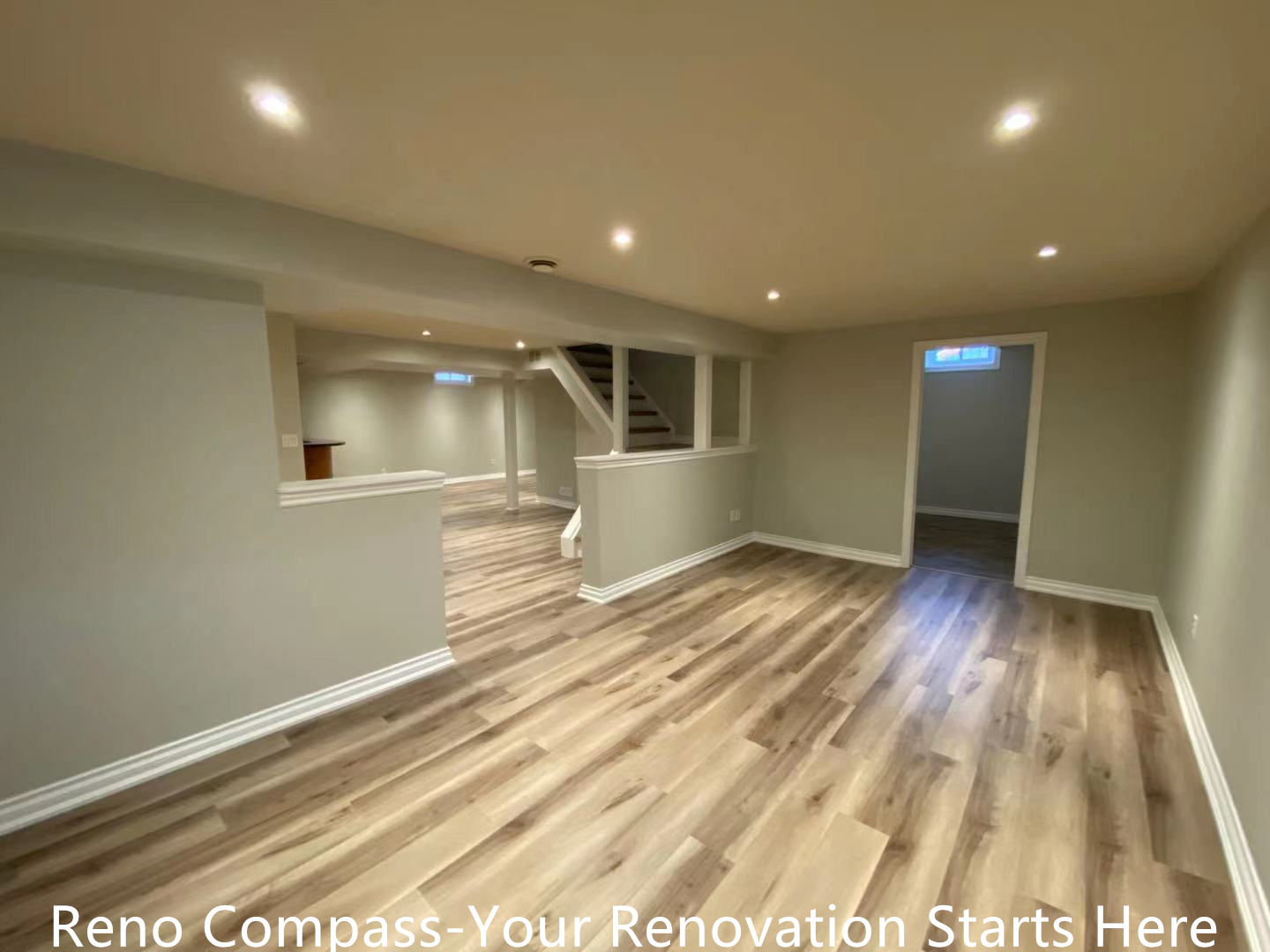 This Oakville interior renovation features a fully finished basement hallway designed to improve flow, comfort, and everyday usability. Continuous wood-look vinyl flooring connects the staircase, main basement area, and bathroom entrance, creating visual consistency throughout the space. Recessed ceiling lights provide balanced illumination, while half-height walls help define circulation zones without making the basement feel enclosed. Neutral wall colors and clean trim details enhance brightness and maintain a modern, cohesive appearance. This thoughtfully planned layout supports multi-purpose basement use and reflects the quality standards of a professional Toronto renovation company.