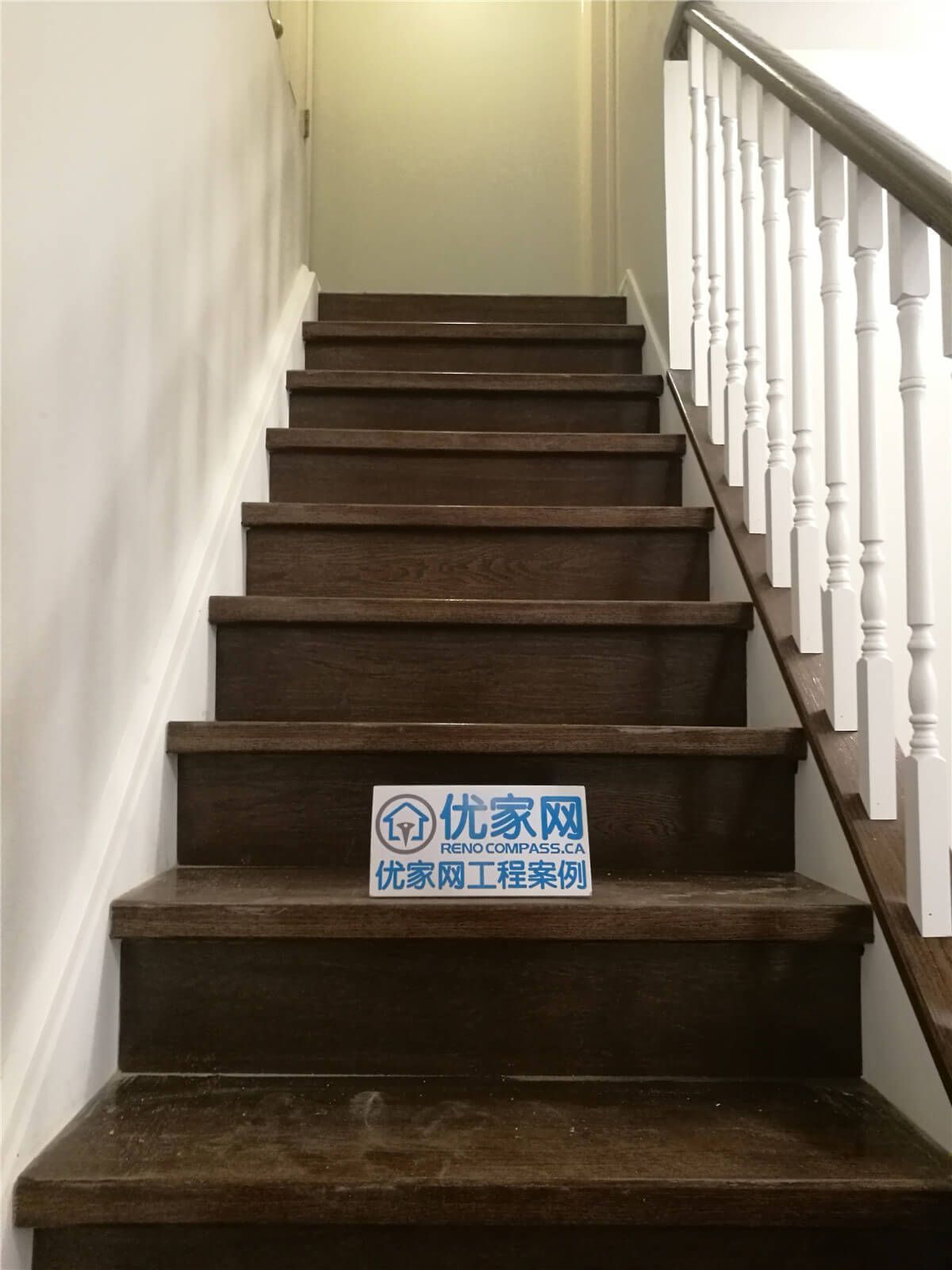 Stylish staircase renovation in Richmond Hill with dark wood treads, white risers, and detailed handrail craftsmanship. A seamless transition element within the complete home renovation by Reno Compass.