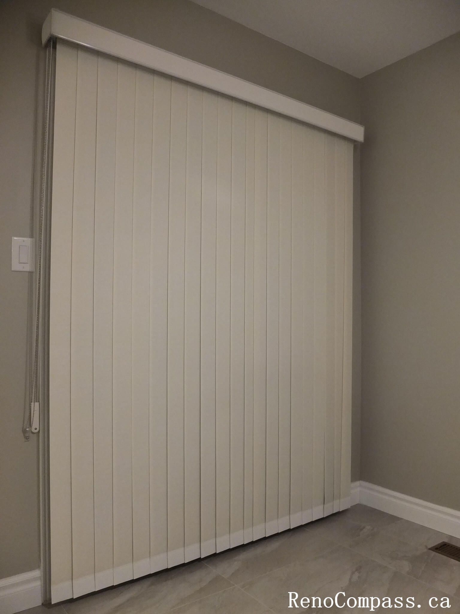 This Richmond Hill curtains installation features custom vertical blinds designed for a large sliding patio door, offering smooth operation, privacy, and effective light control. The neutral-toned vertical slats complement the modern interior and flooring, creating a clean and functional window treatment solution. Professionally measured and installed, these custom blinds enhance energy efficiency and everyday convenience while maintaining a sleek, contemporary appearance. A practical and stylish choice for homeowners in Richmond Hill and the Greater Toronto Area seeking expert curtain and blinds installation.