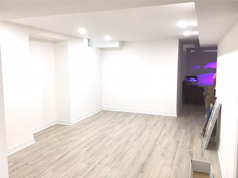 This Aurora basement renovation features a clean and open layout with light-toned flooring and recessed lighting, creating a bright and versatile space. The design allows for flexible use such as a living area, home office, or entertainment zone, maximizing functionality in the finished basement.