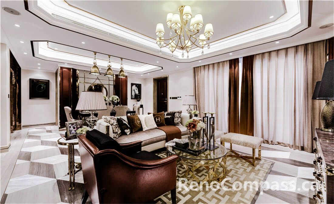 This Toronto interior renovation project showcases a refined luxury living room design featuring a custom tray ceiling with integrated lighting, a statement chandelier, elegant marble flooring, and high-end furniture styling. The space blends classic detailing with modern sophistication, creating a warm yet upscale atmosphere. Designed and built by a professional Toronto Renovation Company, this project highlights craftsmanship, lighting design, and premium interior finishing.