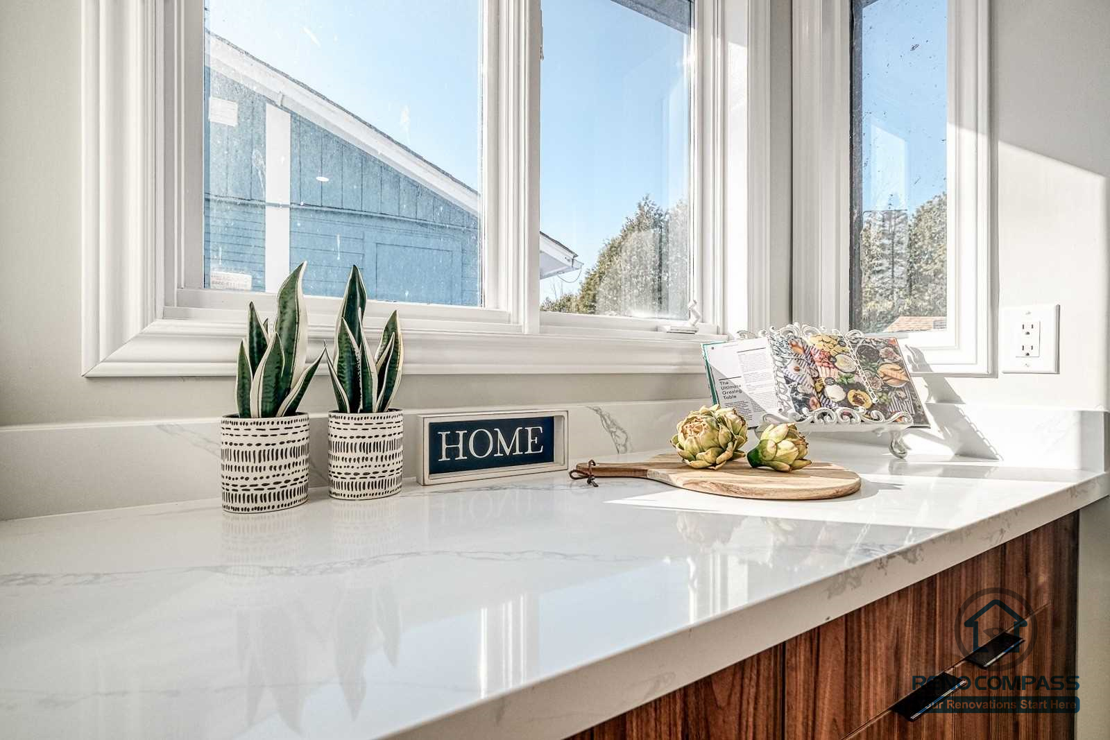 This Georgian interior renovation highlights a clean kitchen countertop detail with natural light, refined window trim, and warm wood cabinetry. Subtle styling and quality finishes reflect the craftsmanship of a Toronto renovation company.