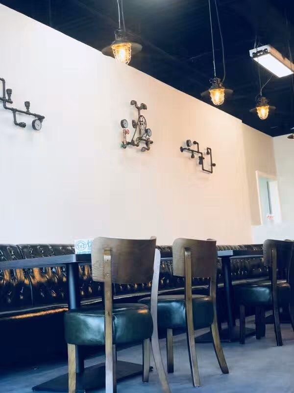Restaurant dining area completed as part of a North York commercial renovation project. The interior features modern seating, leather bench booths, decorative wall art, and warm pendant lighting, creating a comfortable and stylish atmosphere for customers.
