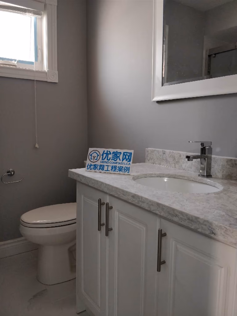 Bathroom renovation project in Ajax featuring a modern white vanity cabinet, quartz countertop, under-mount sink, and updated chrome faucet. The space also includes fresh grey wall paint, a new mirror, and upgraded finishes, creating a clean and functional bathroom design completed by a professional Toronto renovation company.