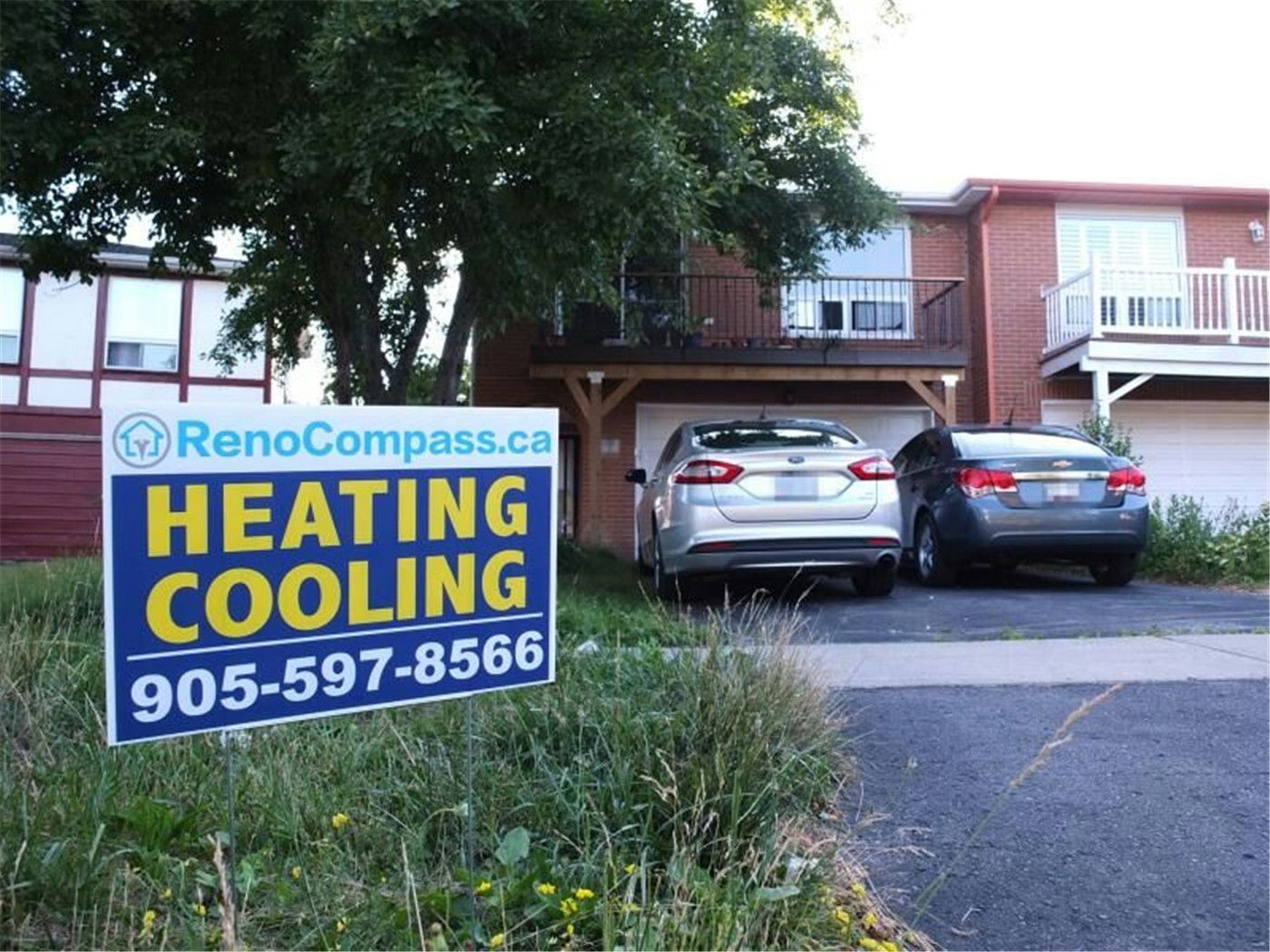 Professional outdoor air conditioner condenser installation by Reno Compass in Toronto. This energy-efficient HVAC unit is securely mounted on a raised stand with proper drainage and ventilation clearance, ensuring optimal cooling performance, durability, and safe operation for residential homes. Installed by licensed technicians for long-term reliability and comfort.
