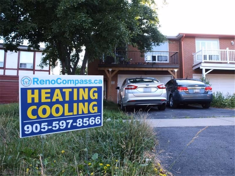 Professional outdoor air conditioner condenser installation by Reno Compass in Toronto. This energy-efficient HVAC unit is securely mounted on a raised stand with proper drainage and ventilation clearance, ensuring optimal cooling performance, durability, and safe operation for residential homes. Installed by licensed technicians for long-term reliability and comfort.