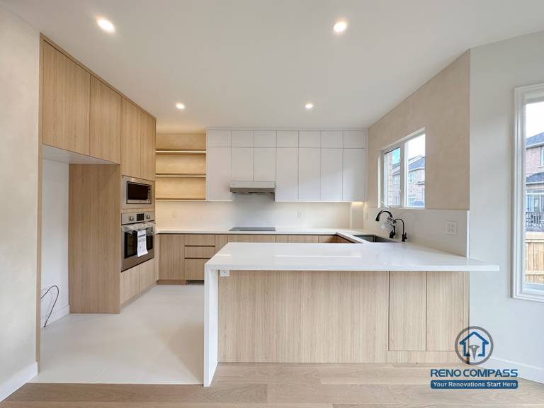 This Markham kitchen renovation features custom wood cabinetry, a spacious central island, and integrated appliances designed to enhance daily functionality. The clean layout, soft lighting, and neutral finishes create a bright, modern kitchen optimized for workflow and long-term use.